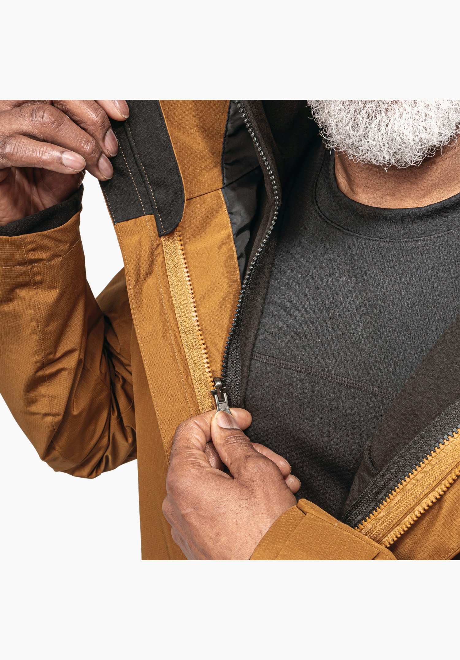3in1 Jacket Style Okere MNS features the front zip and the connection to the dark inner jacket, surrounded by the brown outer fabric, close-up against a white/neutral background.