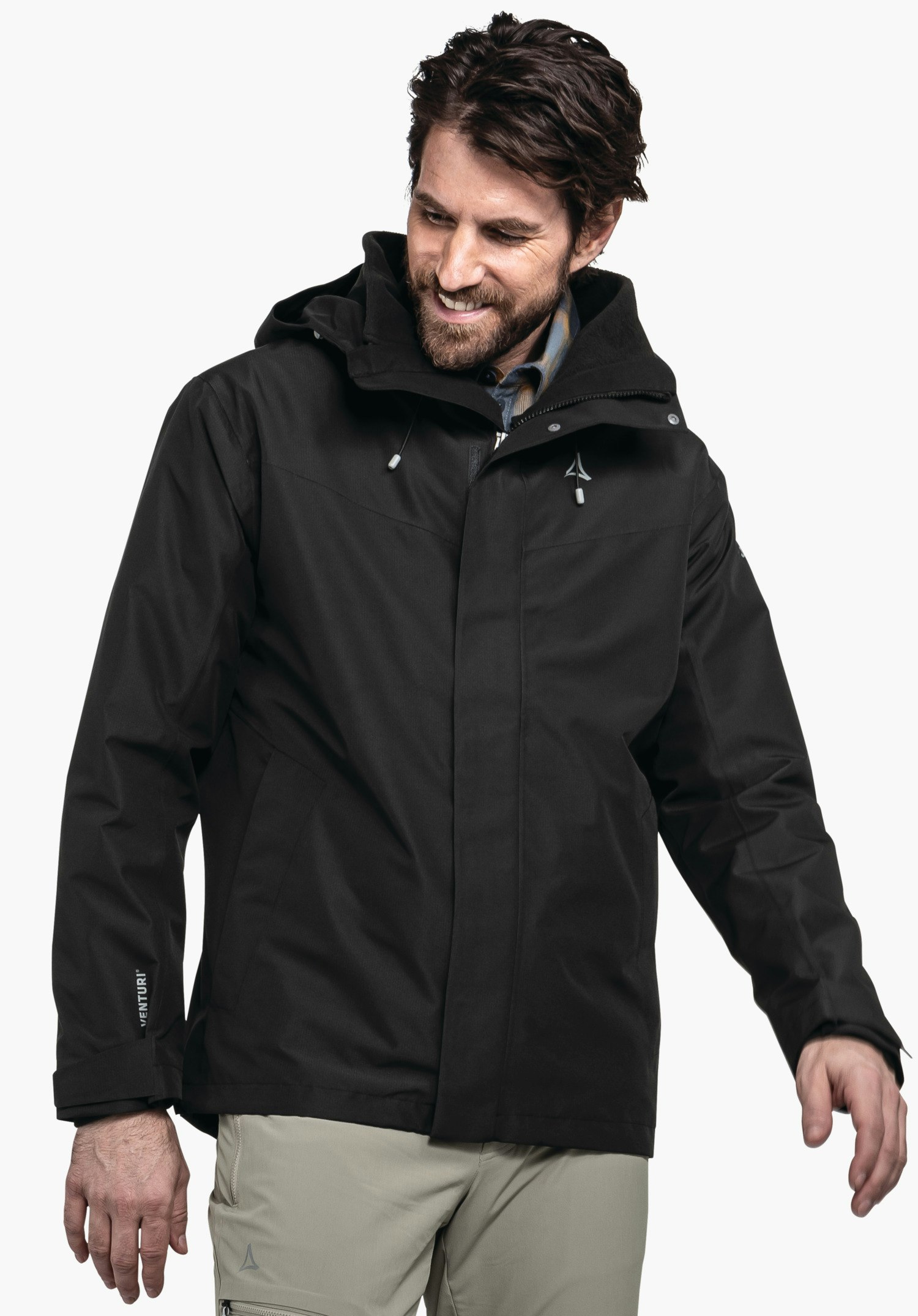 3in1 Jacket Style Okere MNS schwarze Jacke — Mann trägt sie, lächelt und blickt leicht nach unten; Kapuze an; Schöffel-Logo auf der Brust; Ärmeltext: VENTURI; weißer Hintergrund.