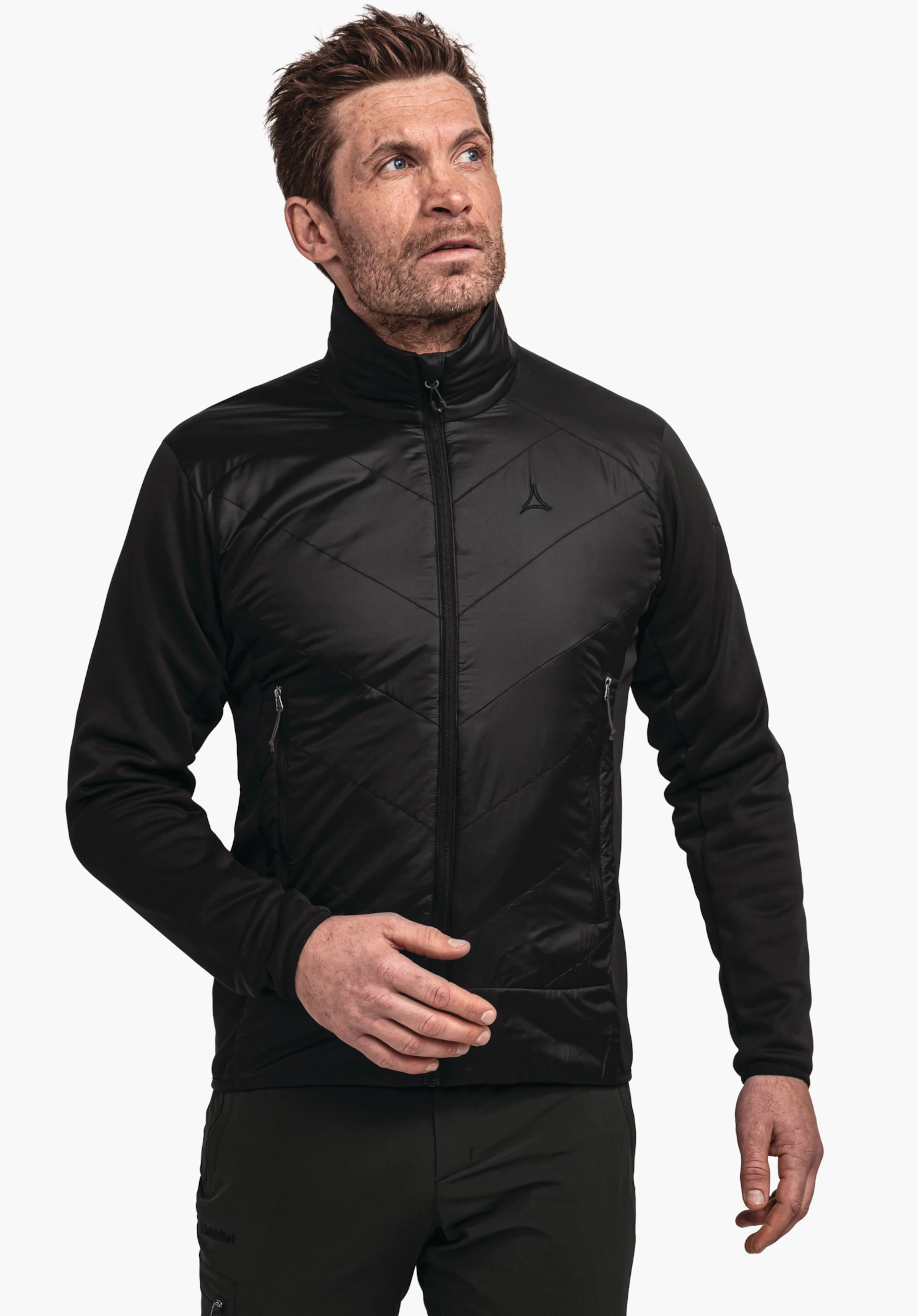Fleece Jk Style Qutang MNS donkeroranje fleecejas, gedragen door een staande man die licht omhoog kijkt; Schöffel-logo op de borst, rits gesloten, zwarte broek, witte achtergrond.