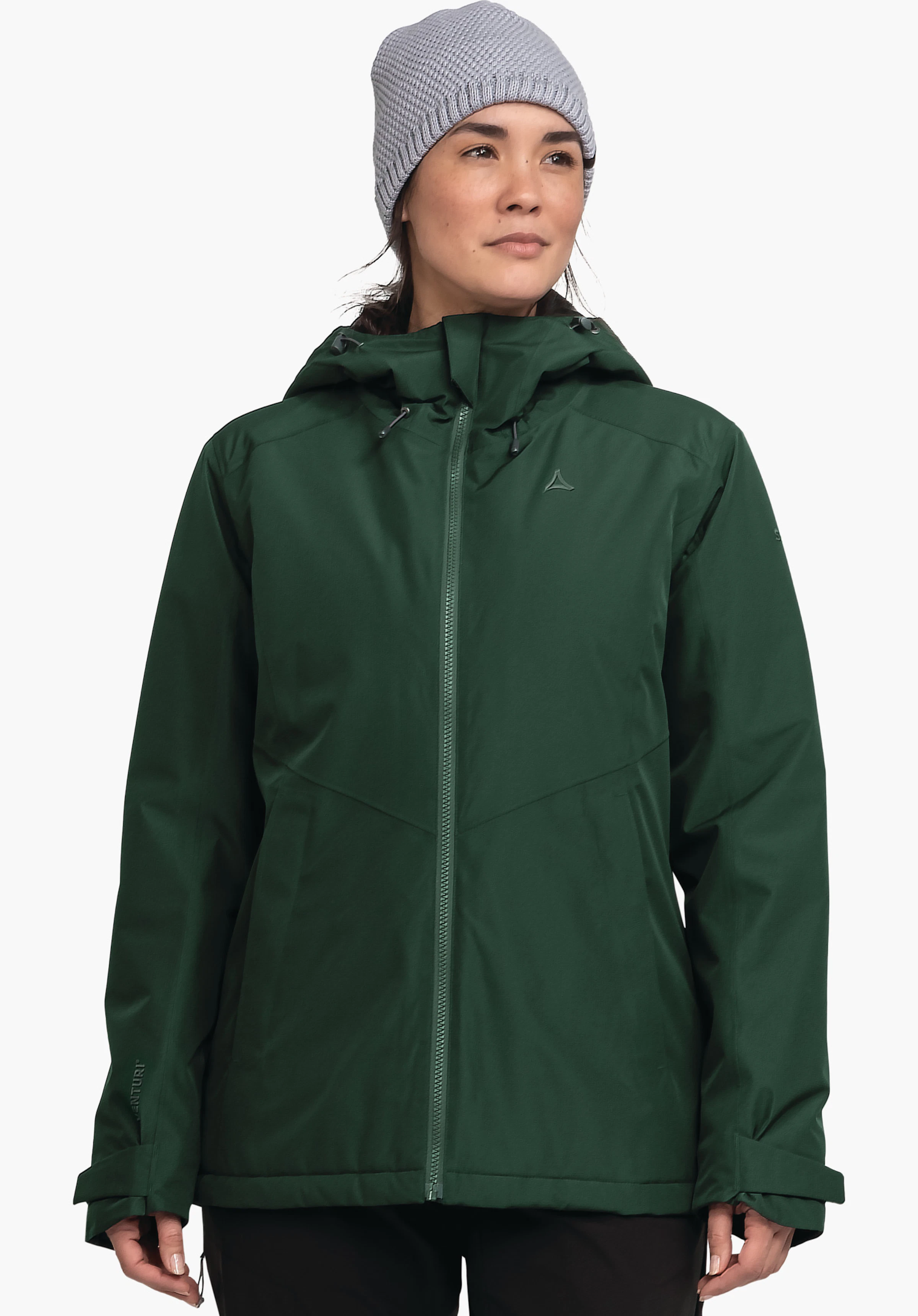 Ins Jacket Style Wildkar WMS Femme portant une veste vert foncé, entièrement zippée, avec capuche et cordon de serrage; logo Schöffel sur la poitrine; modèle debout devant un fond blanc. Texte: VENTURI.