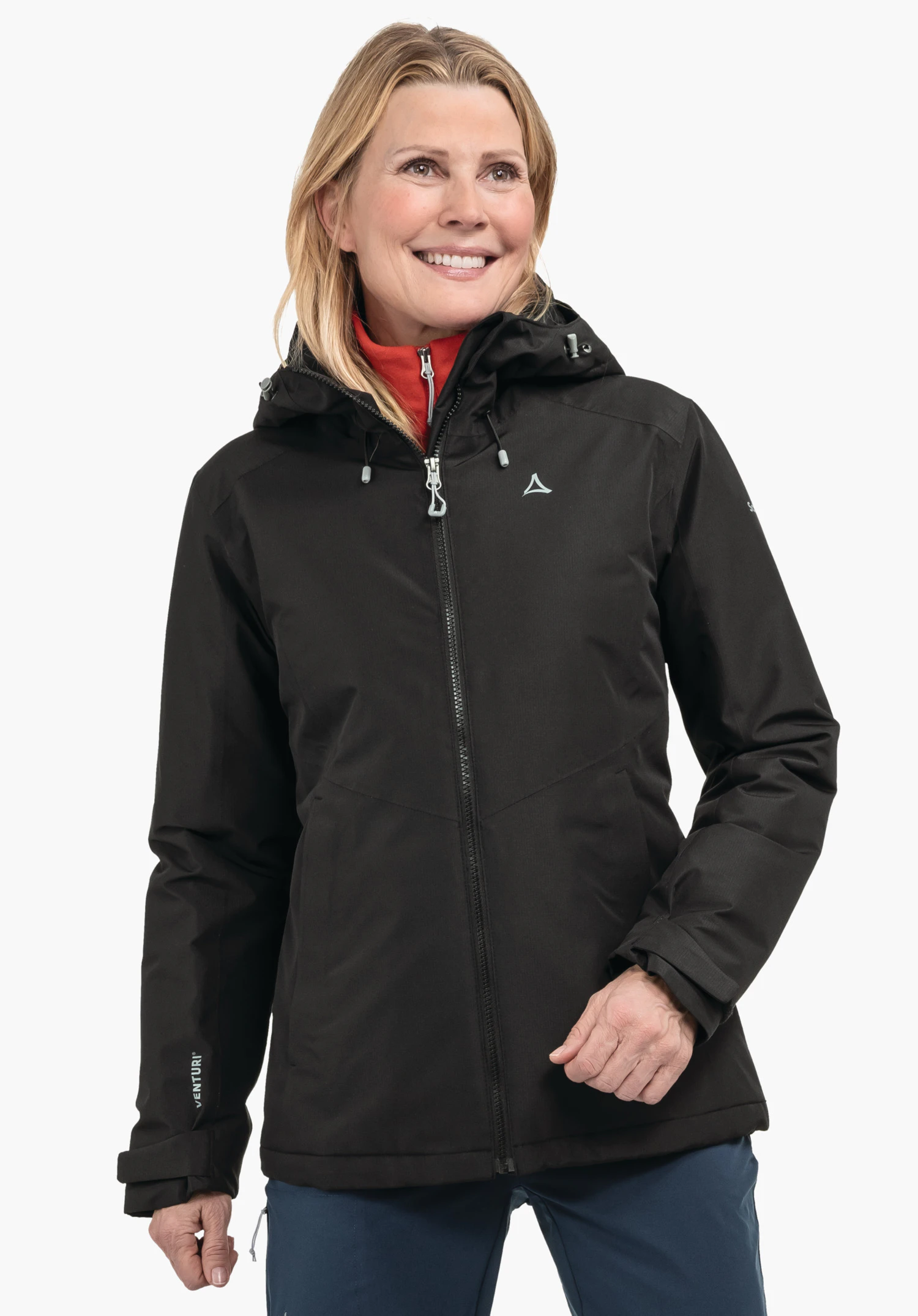 Ins Jacket Style Wildkar WMS Schwarze Jacke mit Schöffel-Logo; Frau trägt sie geschlossen, lächelnd; roter Kragen sichtbar, blaue Hose, neutraler heller Hintergrund. Text auf Ärmel: "VENTURI".