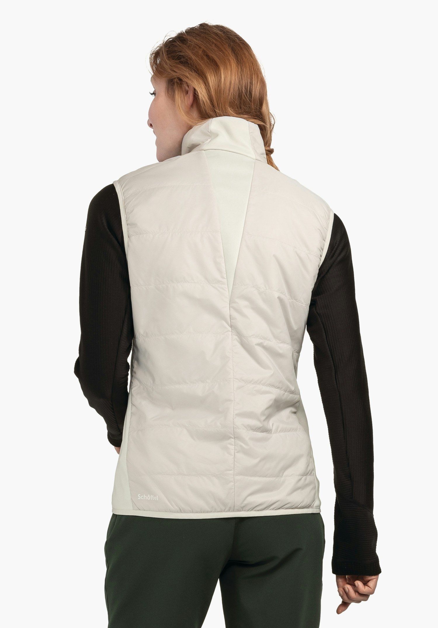 Hybrid Vt Style Cascata WMS gilet matelassé blanc clair, porté par une personne tournée dos à la caméra; t-shirt manches longues noir visible et pantalon vert foncé; fond studio clair. Texte: « Schöffel ».
