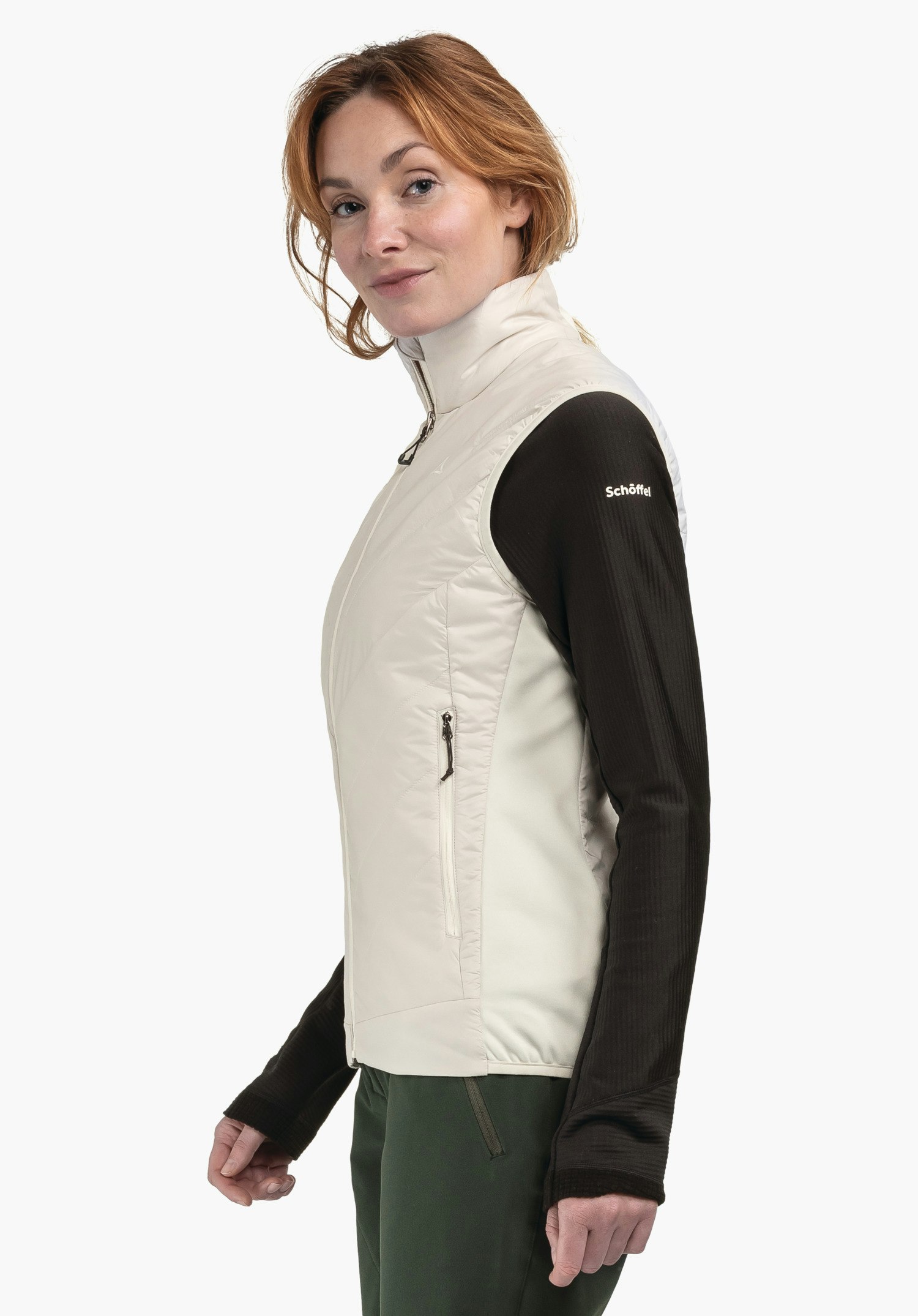 Hybrid Vt Style Cascata WMS gilet femme: femme portant un gilet blanc clair, debout de profil et regardant la caméra; dessous t-shirt manches longues noir, pantalon vert; texte "Schöffel" sur la manche gauche.
