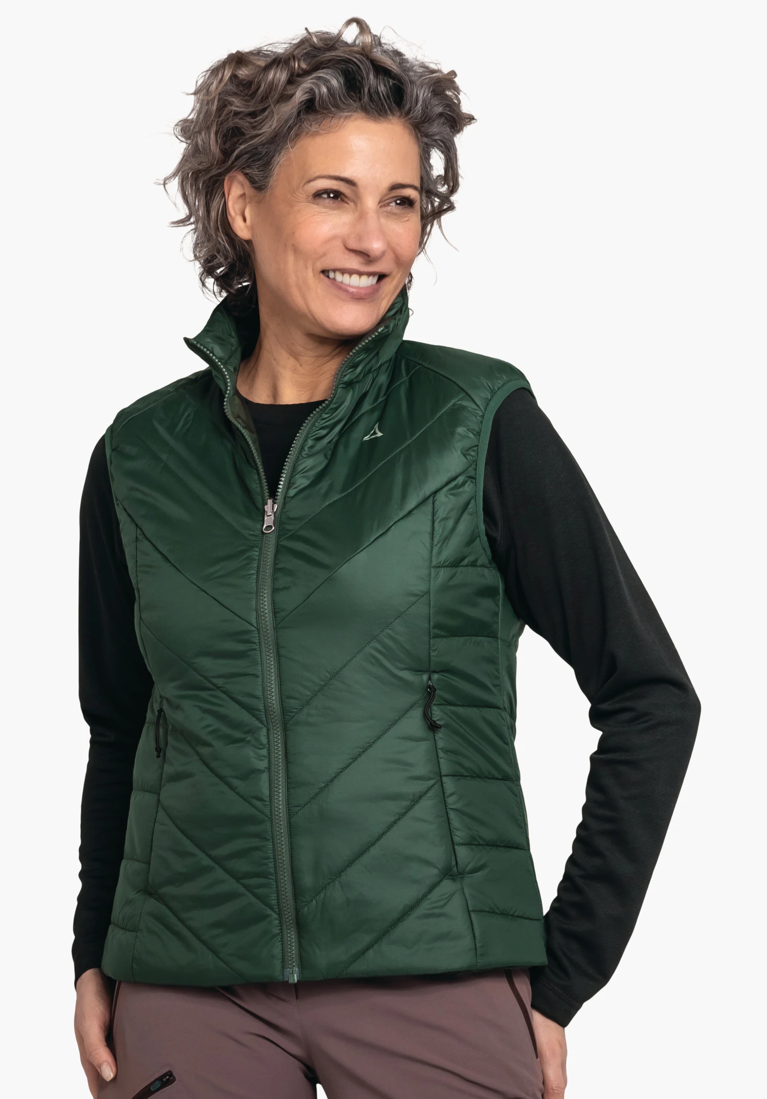 Ins Vest Style Yew WMS dark green quilted gilet, worn by a smiling person with hands in pockets against a plain light background; Schöffel logo on the left chest.