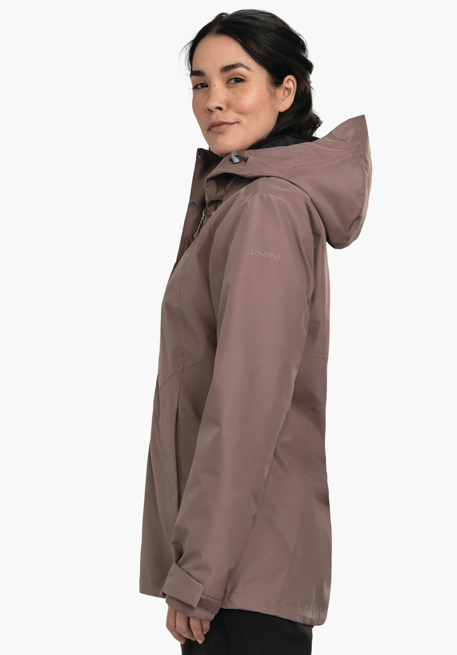 3in1 Jacket Style Okere WMS Dunkel lila Regenjacke mit Kapuze, von Frau seitlich getragen; sie blickt leicht zur Kamera, weißer Hintergrund. Text auf Ärmel: "Schöffel".