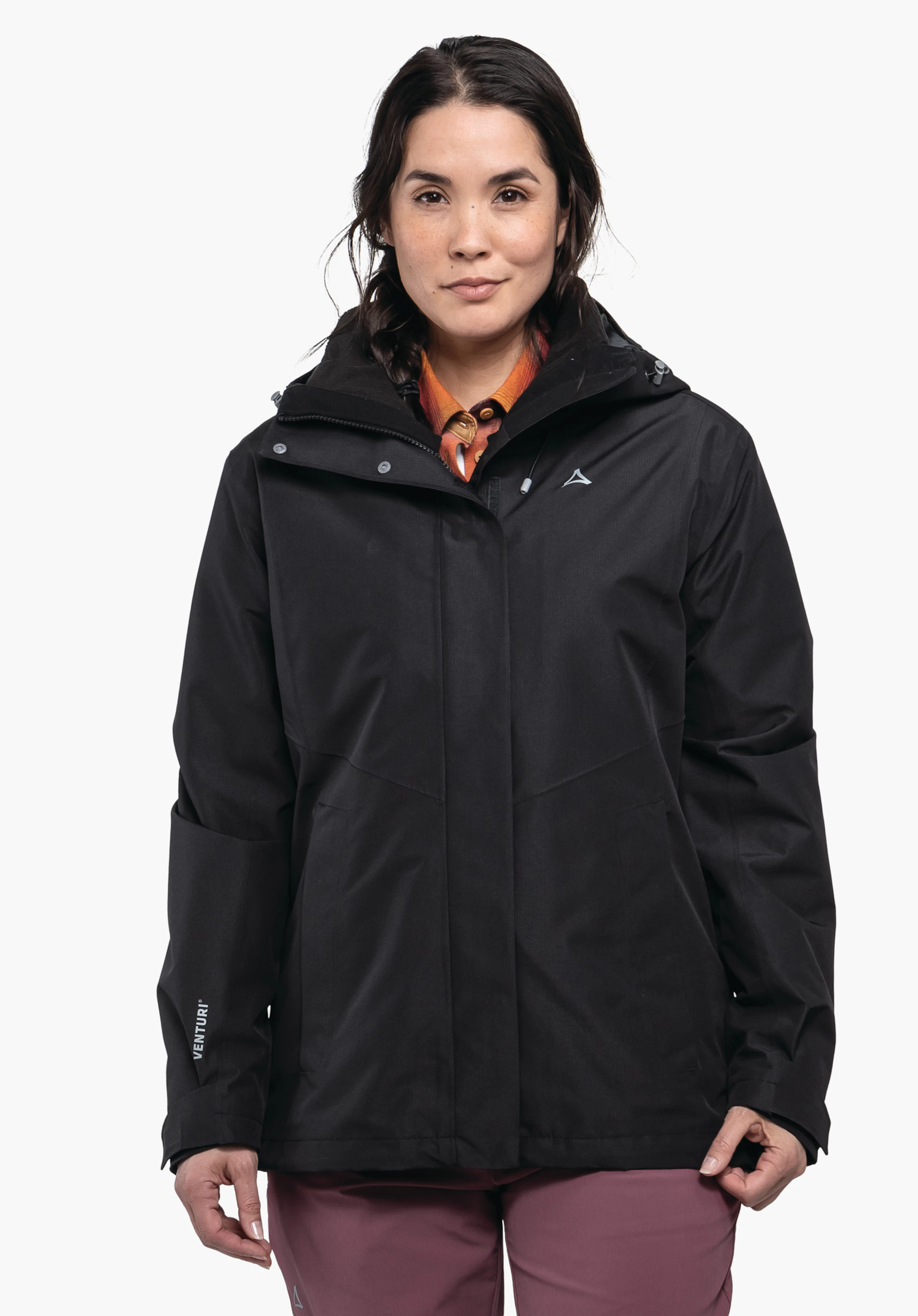 3in1 Jacket Style Okere WMS Schwarze Jacke, getragen von einer frontal stehenden Person vor weißem Hintergrund; Schöffel-Logo auf der Brust, Schriftzug "VENTURI" am linken Ärmel; orange Hemdkragen sichtbar, rosa Hose.