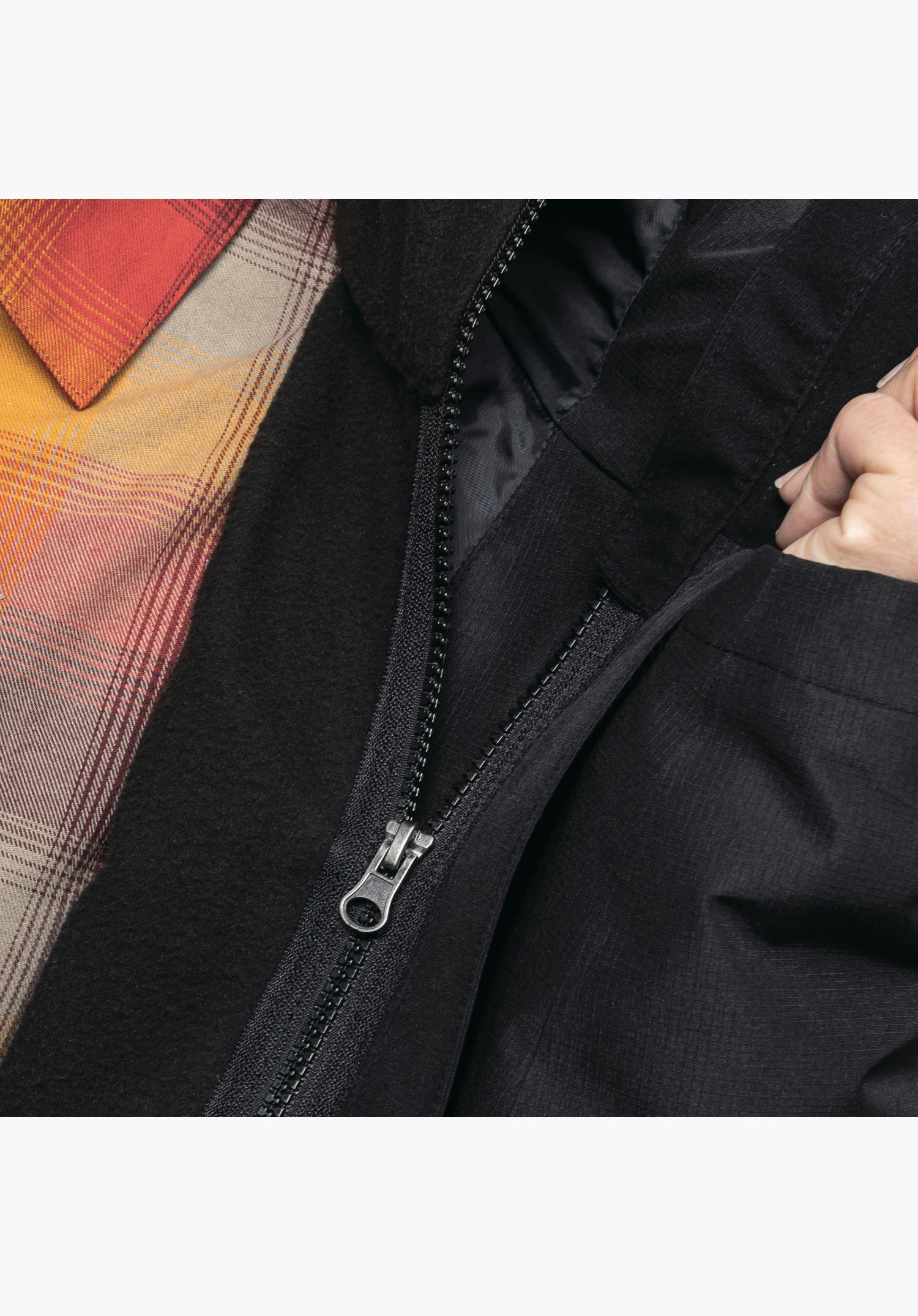 3in1 Jacket Style Okere WMS montre la fermeture éclair reliant la veste intérieure noire à la couche extérieure en gros plan sur fond blanc/neutre.