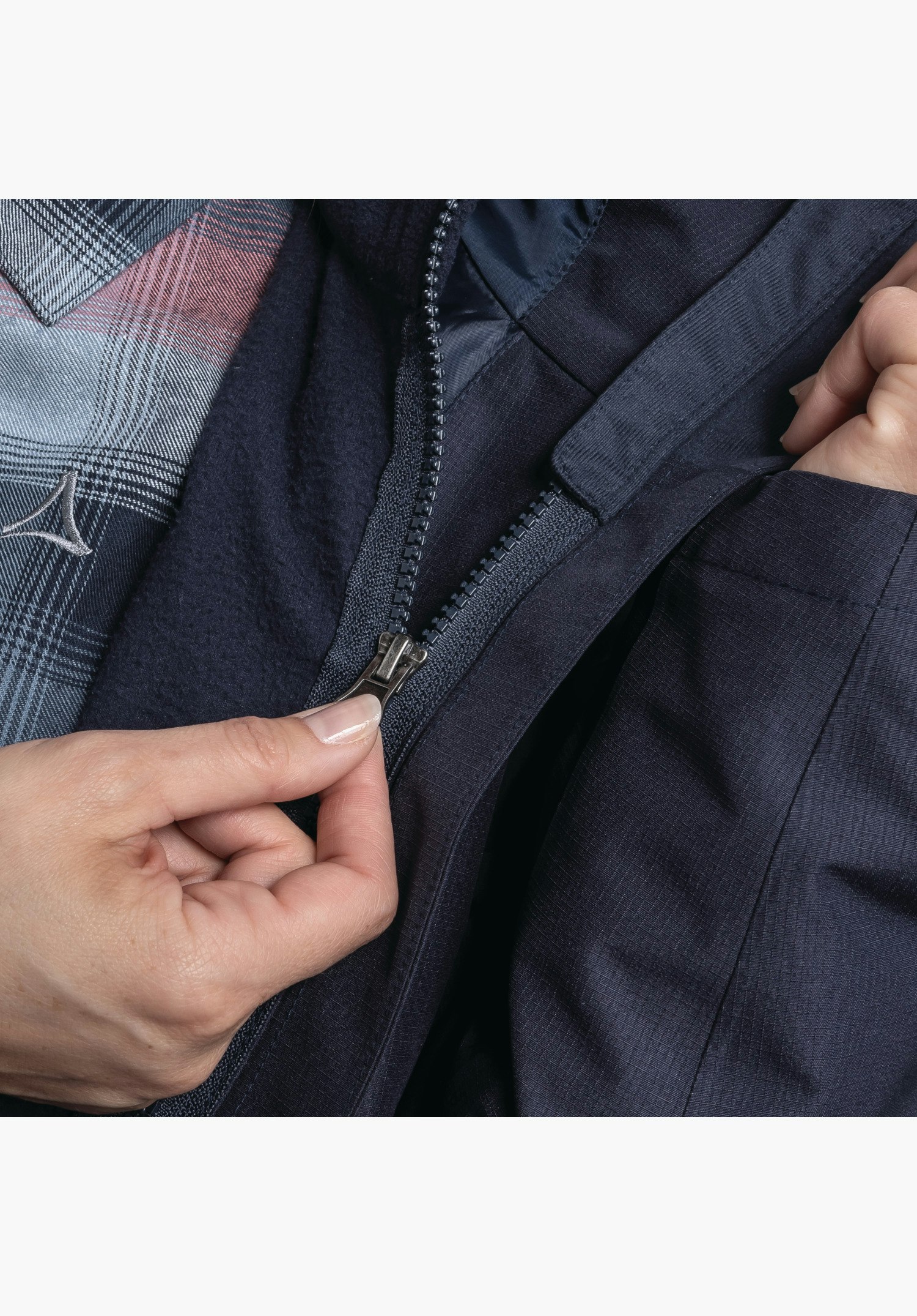 3in1 Jacket Style Okere WMS, détail de la fermeture éclair reliant la veste intérieure en polaire bleue à la veste extérieure, gros plan sur fond blanc/neutre.