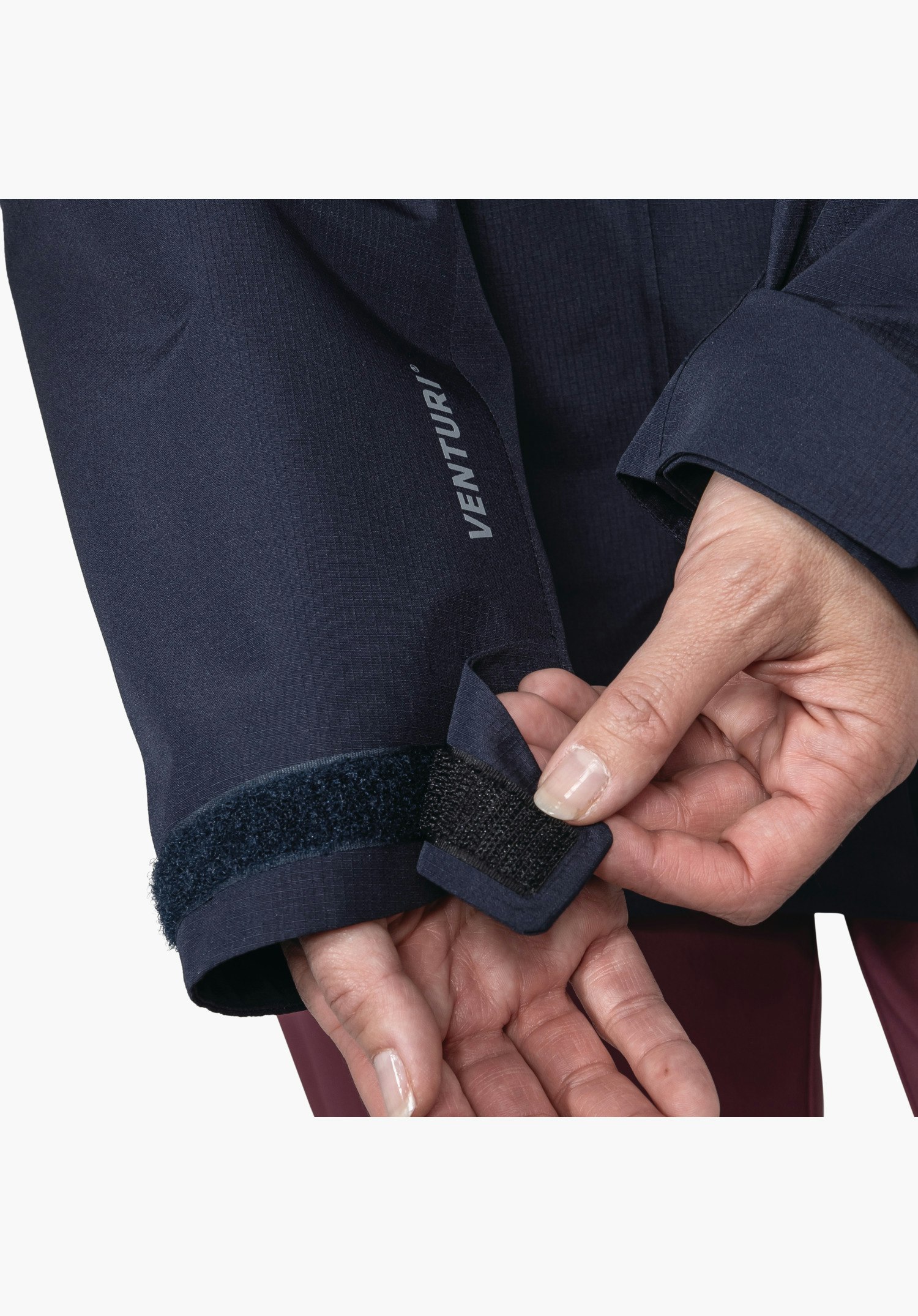 3in1 Jacket Style Okere WMS montre le poignet de la veste bleue avec une fermeture velcro réglable et l'inscription Venturi grise, gros plan sur fond blanc/neutre.