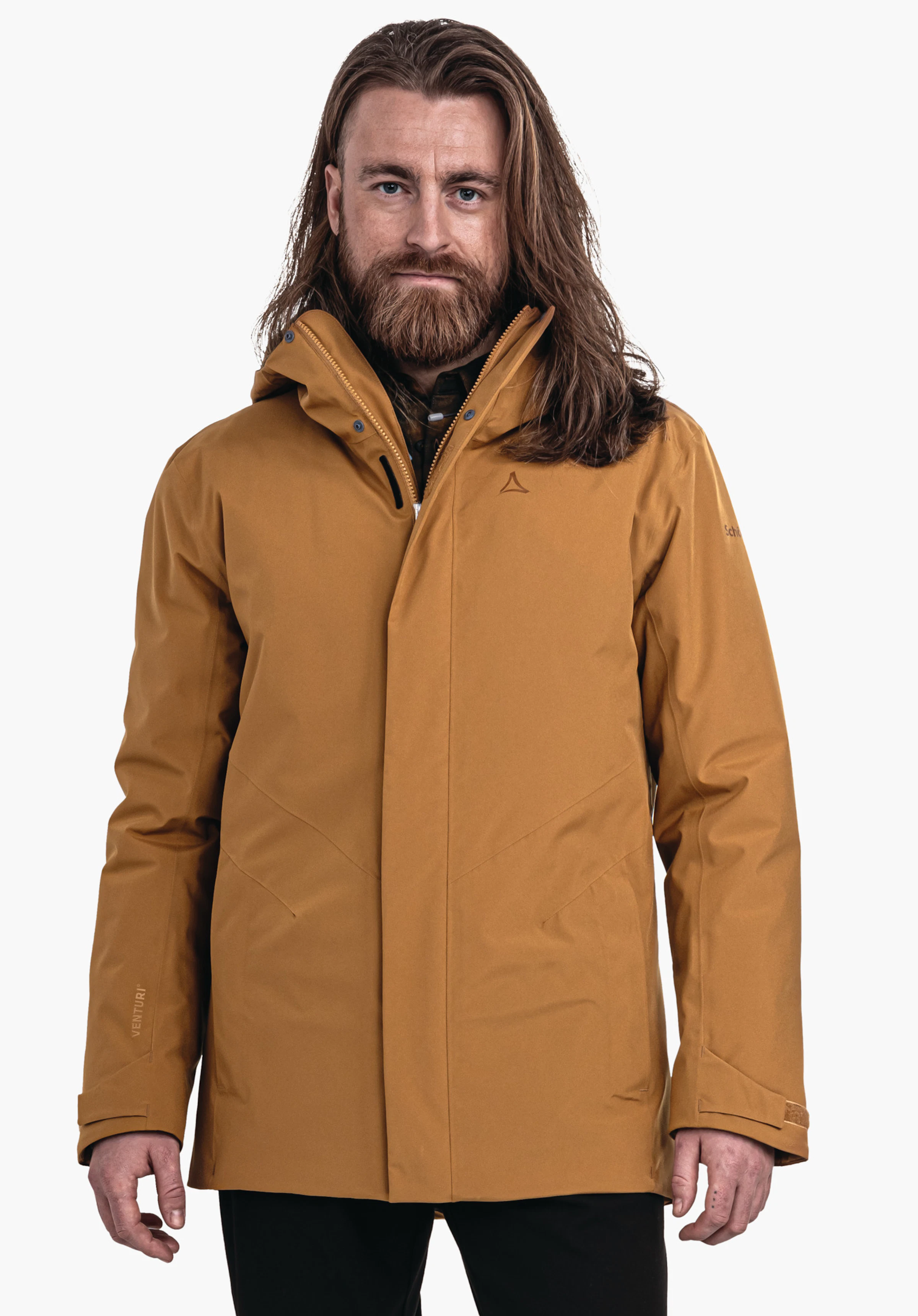 Parka Style Froda MNS Mann trägt orange Kapuzenjacke mit Schöffel-Logo, steht frontal und blickt in die Kamera vor neutralem hellem Hintergrund. Text auf Ärmeln: "VENTURI", "schöffel".