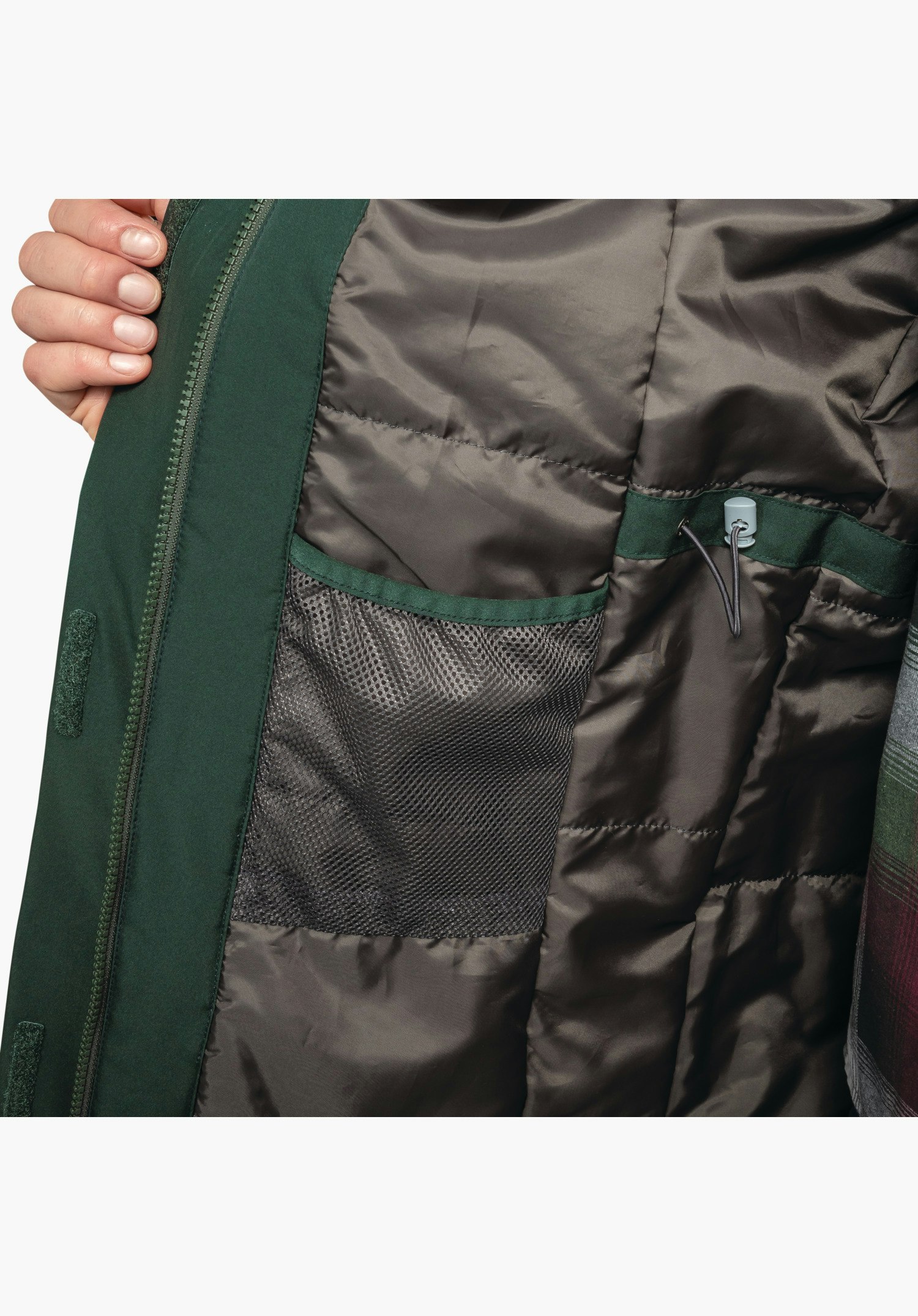 Parka Style Froda WMS vue intérieure montrant le cordon de réglage à la taille et la poche en filet dans la doublure matelassée grise près du zip vert, gros plan sur fond neutre.