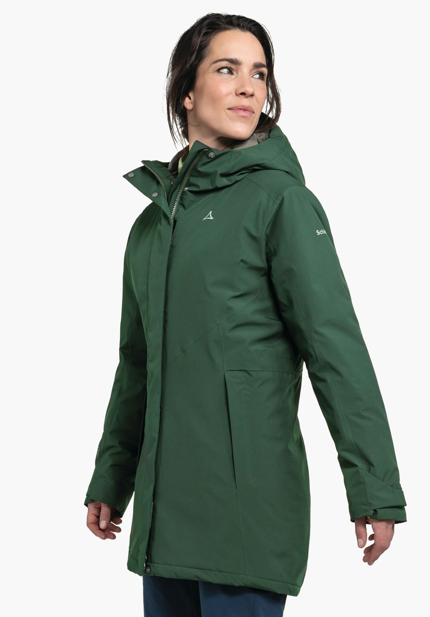 Parka Style Froda WMS parka vert foncé portée par une femme regardant de profil; logo Schöffel sur la poitrine, inscription "Schöffel" sur la manche; fond blanc neutre.