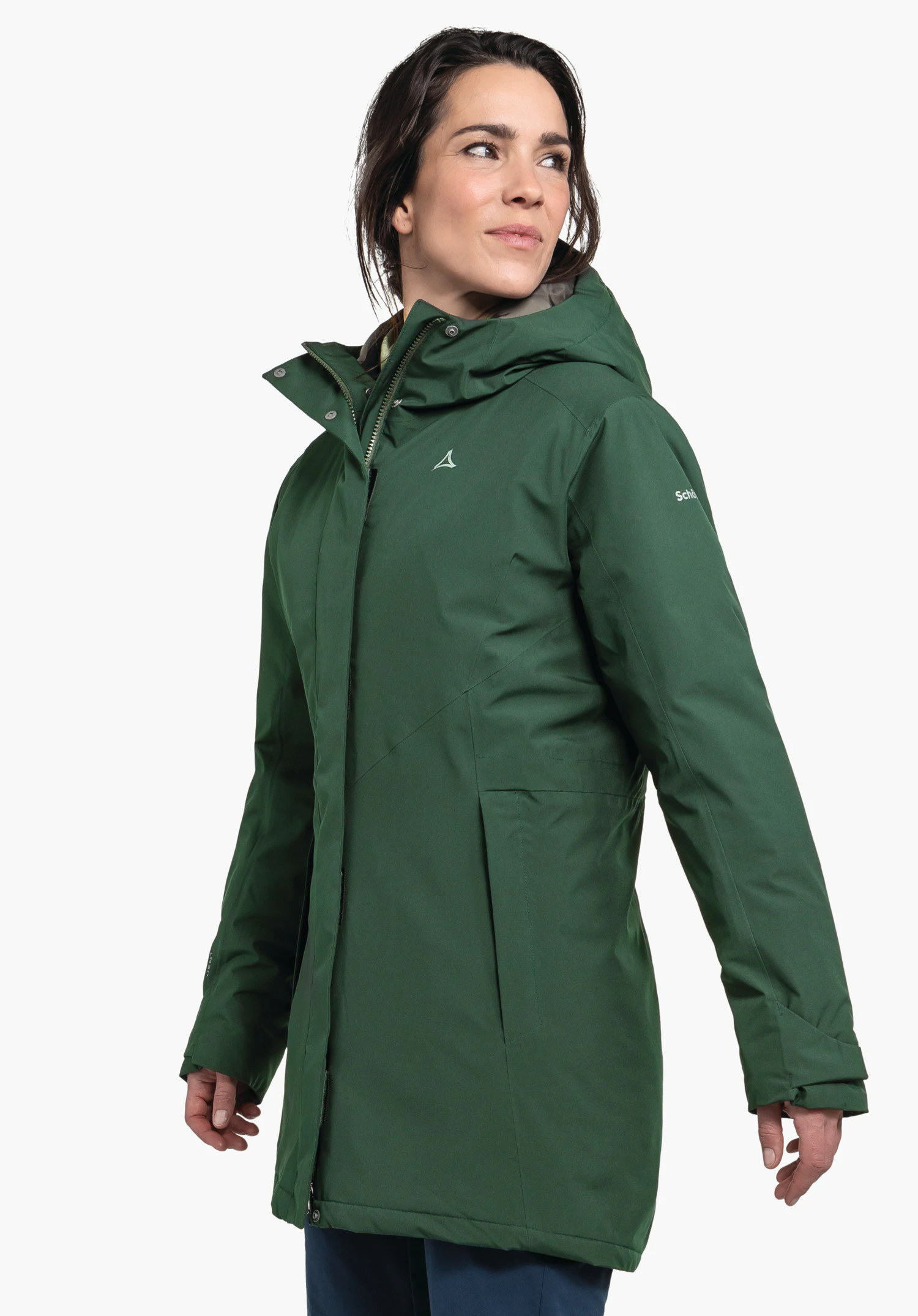 Parka Style Froda WMS parka vert foncé portée par une femme regardant de profil; logo Schöffel sur la poitrine, inscription "Schöffel" sur la manche; fond blanc neutre.