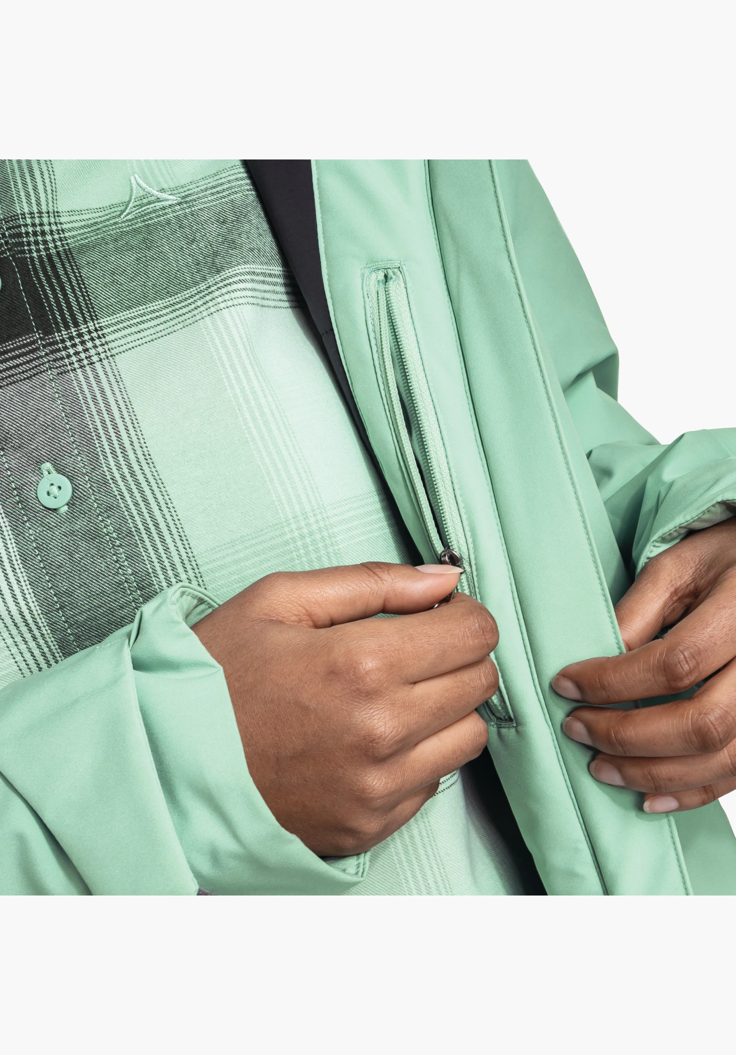 Parka Style Froda WMS : vue détaillée de la poche zippée verte, avec des mains manipulant la tirette. Gros plan sur fond neutre.