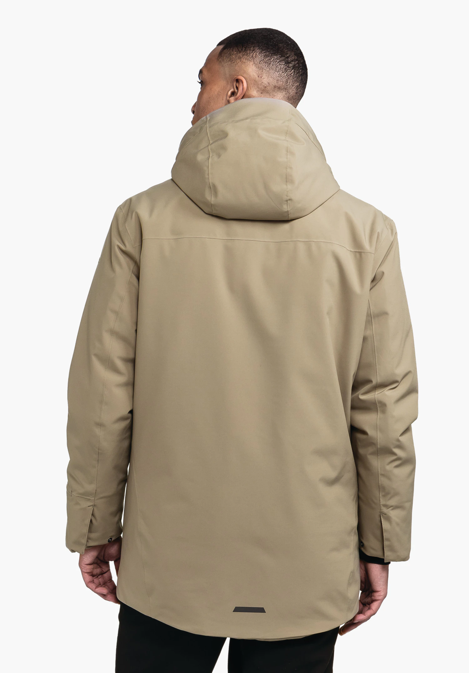 Ins Parka Style Crivat MNS Hellbrauner Parka; Person trägt ihn mit hochgestellter Kapuze, steht mit dem Rücken zur Kamera vor schlichtem weißem Hintergrund.