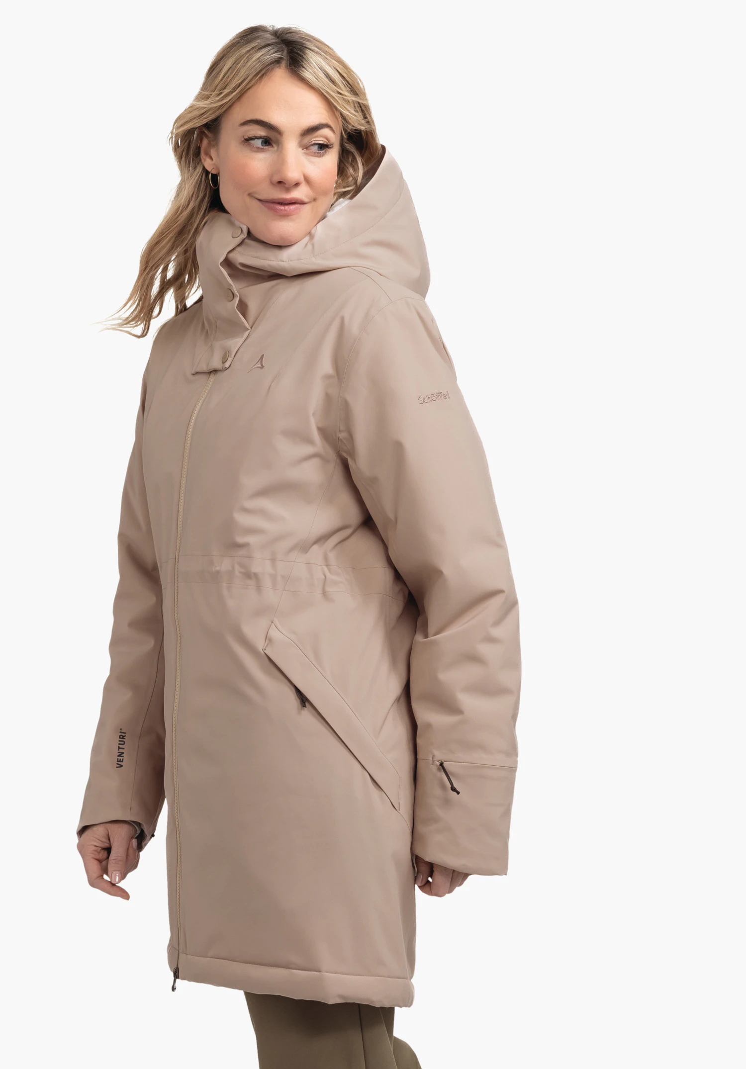 Ins Parka Style Crivat WMS light brown parka worn by a woman; she stands slightly side-on and looks to the right; neutral light background. Schöffel logo visible. Text: "VENTURI", "Schöffel".