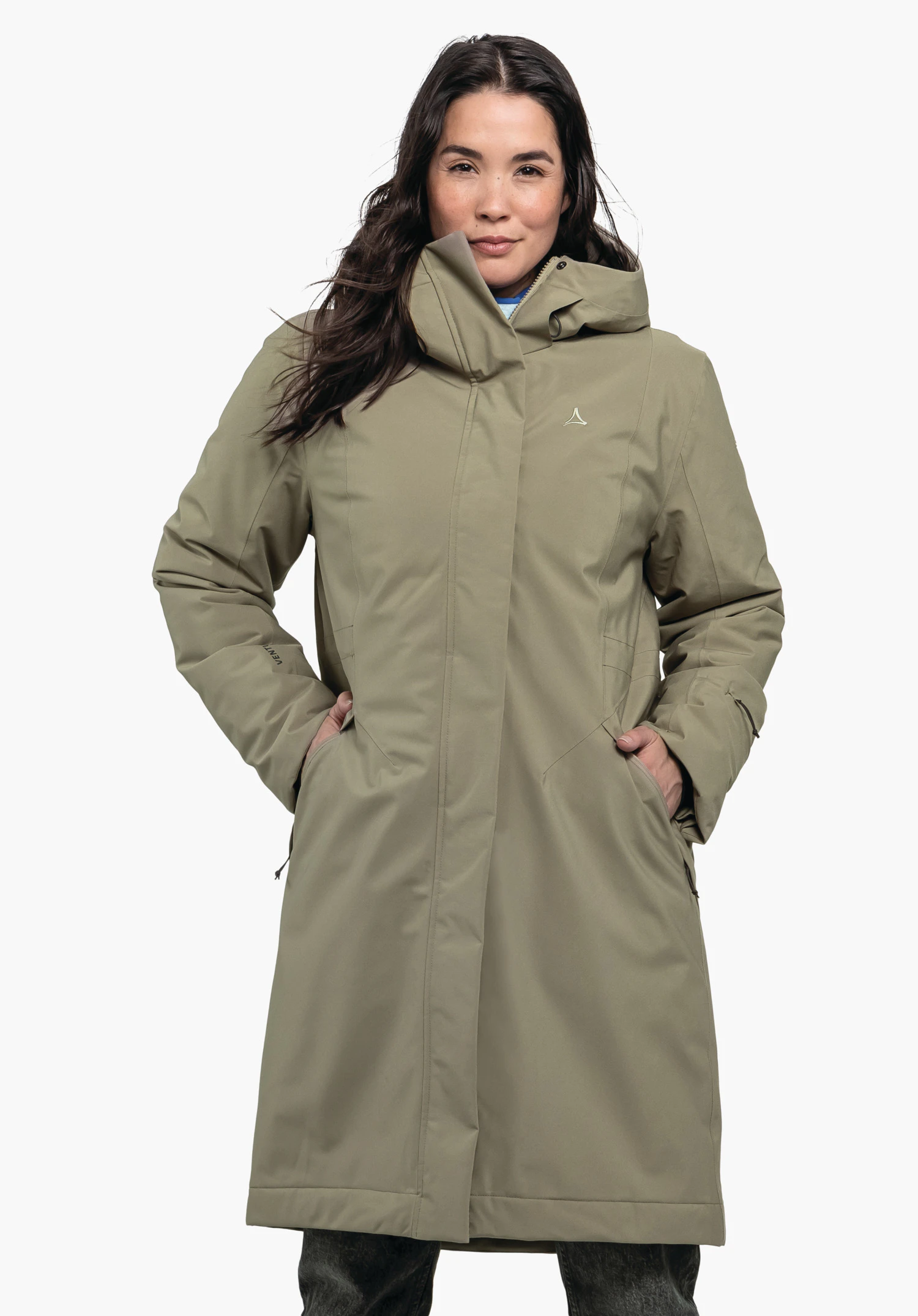 Ins Coat Style Gregale WMS hellgrüner Mantel, getragen von Person, steht frontal, Hände in Taschen steckend; Schöffel-Logo auf Brust; weißer Studiohintergrund.