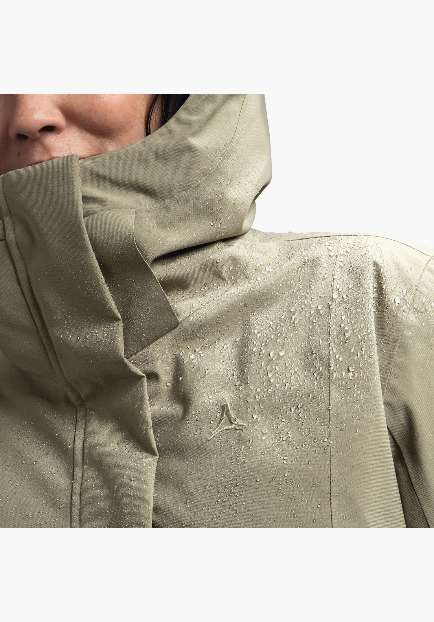 Ins Coat Style Gregale WMS zeigt den wasserabweisenden, braunen Stoff mit abperlenden Wassertropfen im Schulterbereich und das Schöffel-Logo auf der Brust. Nahaufnahme vor weißem/neutralem Hintergrund.