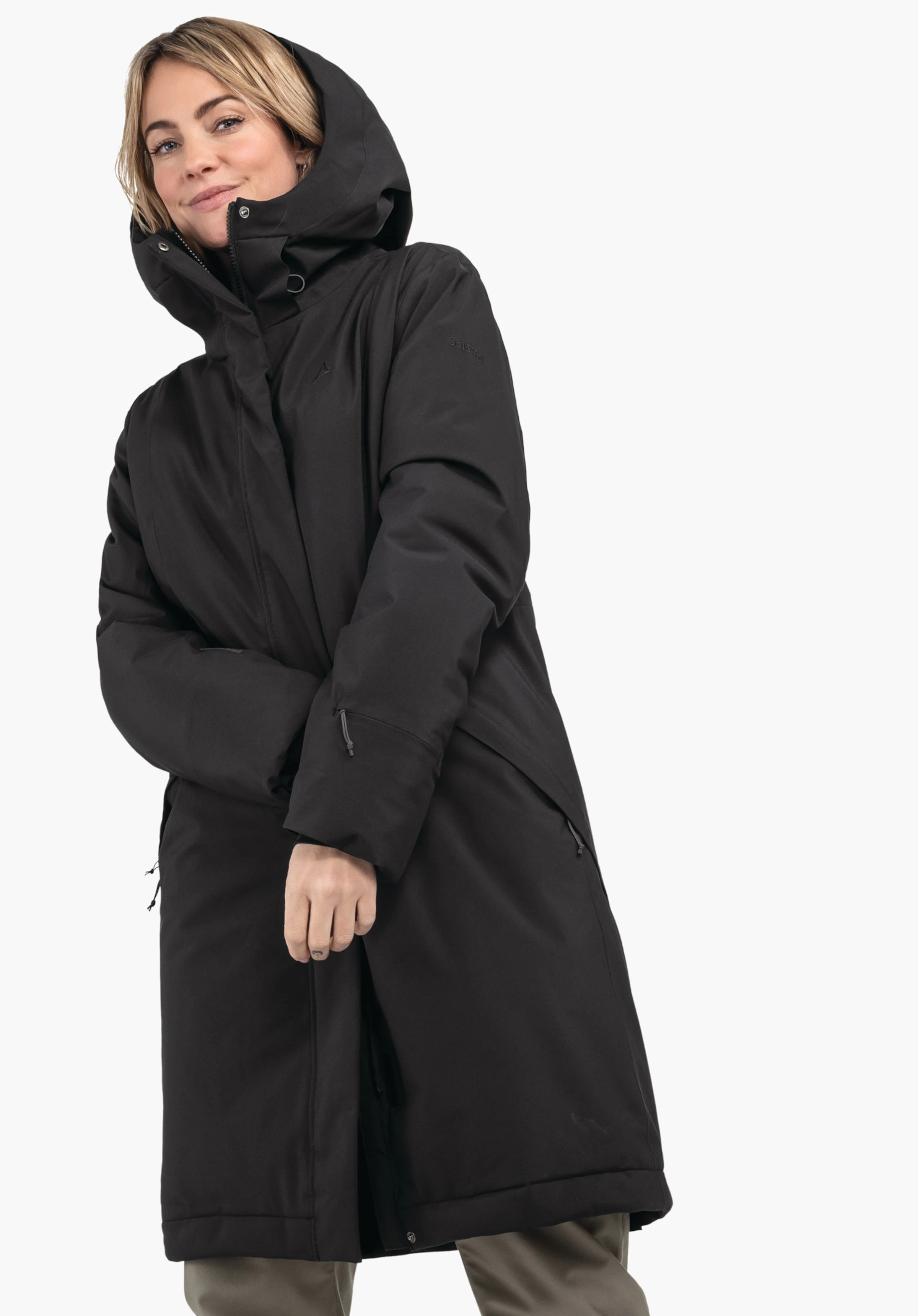 Ins Coat Style Gregale WMS black parka with hood worn by a woman; hood up, hands held in front, concealed zip; Schöffel logo on the chest; white background.