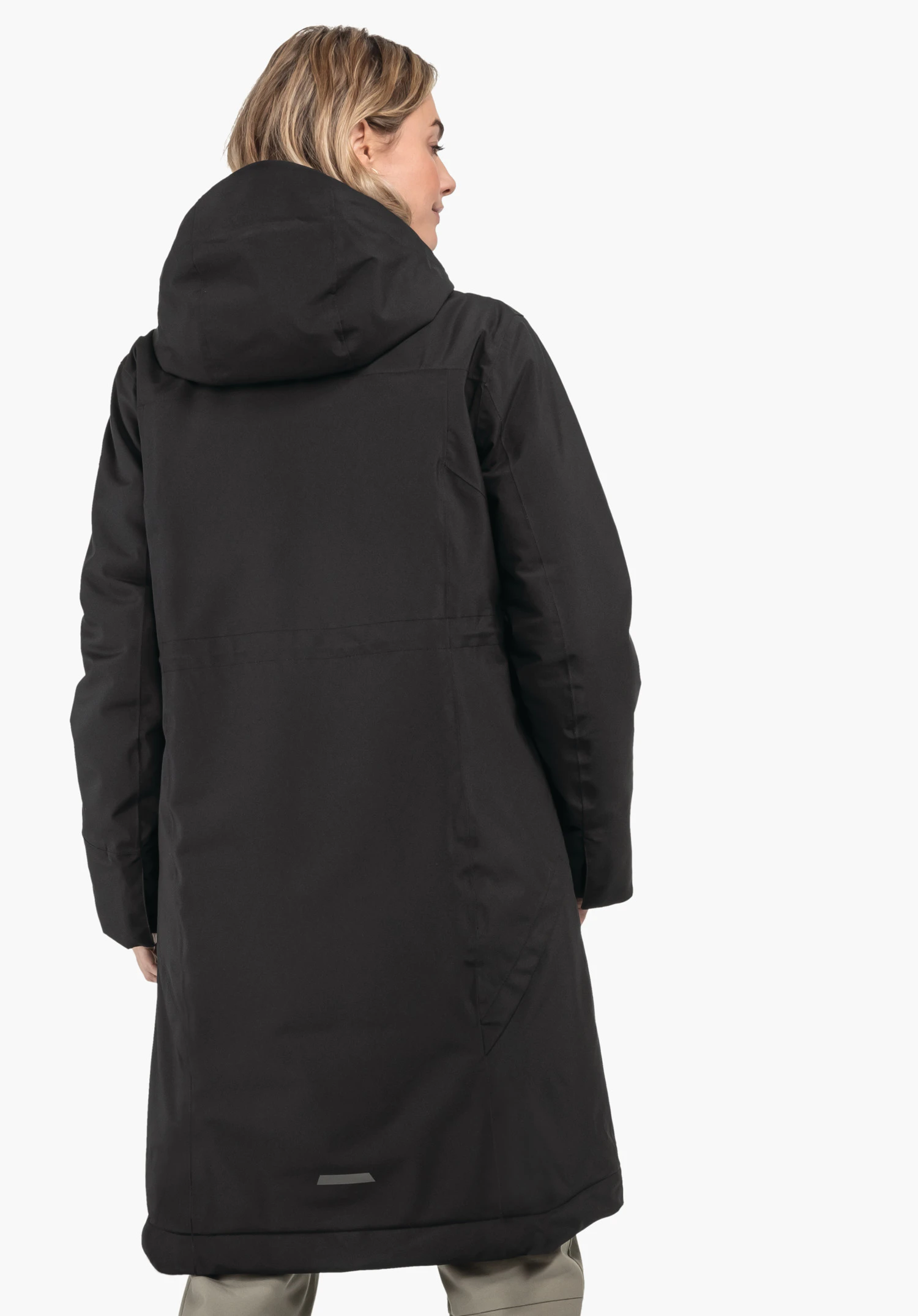 Ins Coat Style Gregale WMS langer schwarzer Mantel, Person trägt ihn und steht mit dem Rücken zur Kamera; Kapuze auf dem Rücken; freier weißer Hintergrund; hellbeige Hosen sichtbar.