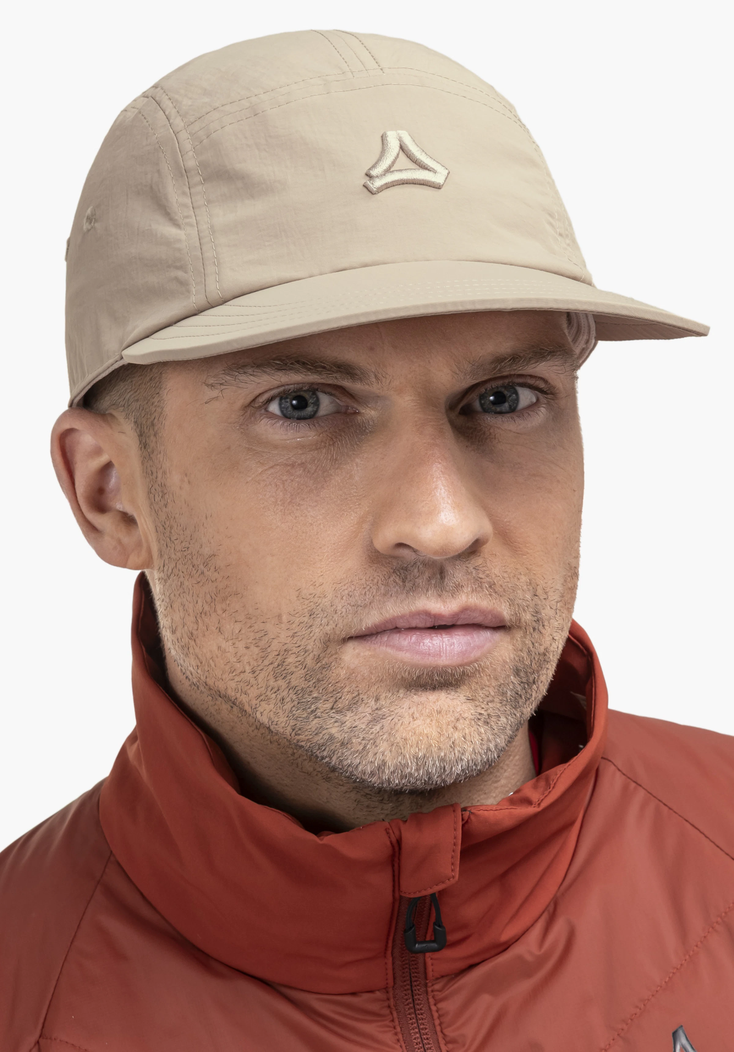 Sun Cap in beige: A model looks directly into the camera while wearing the cap against a neutral background. The subtle Schöffel logo is positioned centrally on the front.