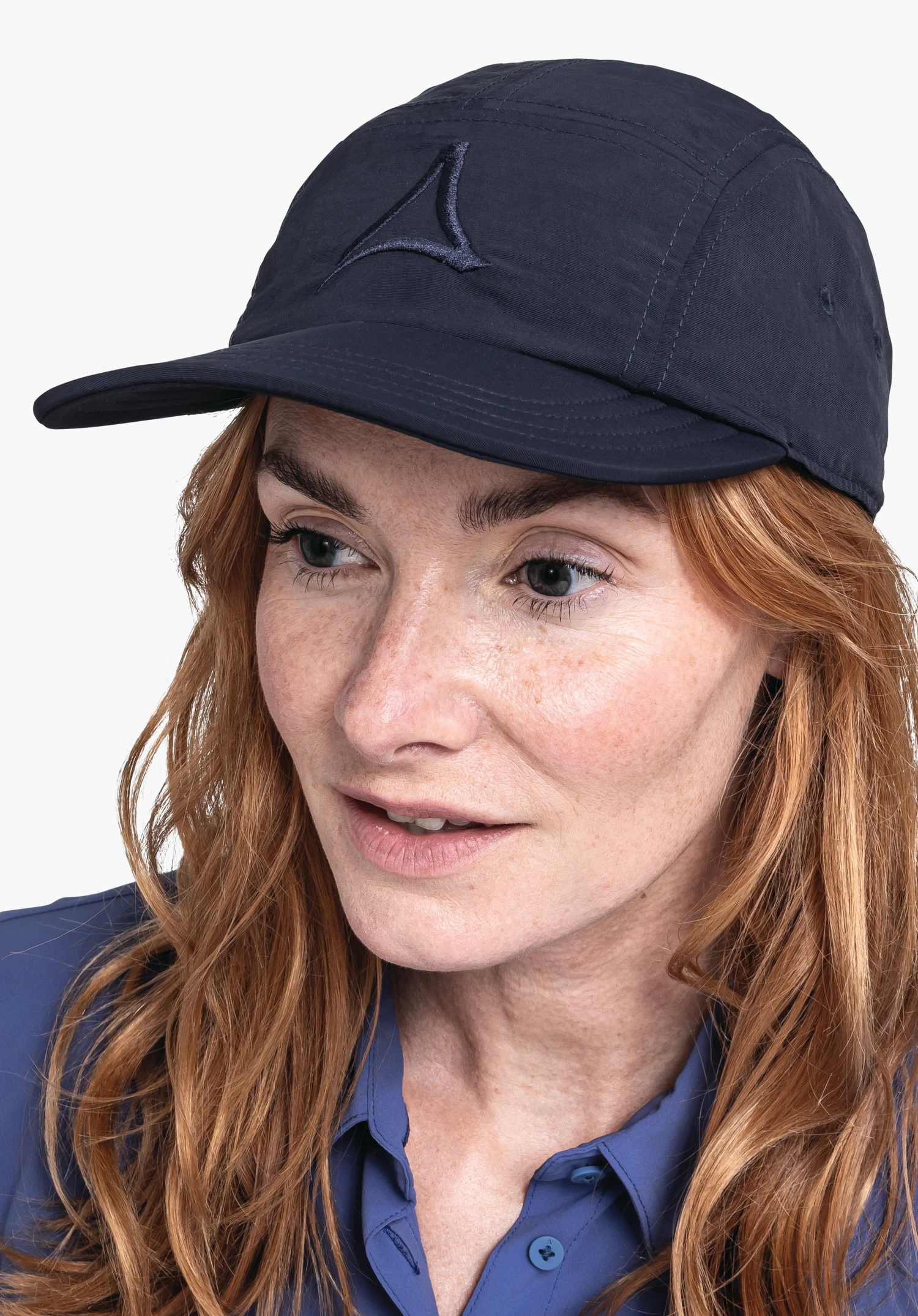 Sun Cap in blue worn by a woman in semi-profile against a neutral background. The subtle Schöffel logo is clearly visible on the front of the cap.