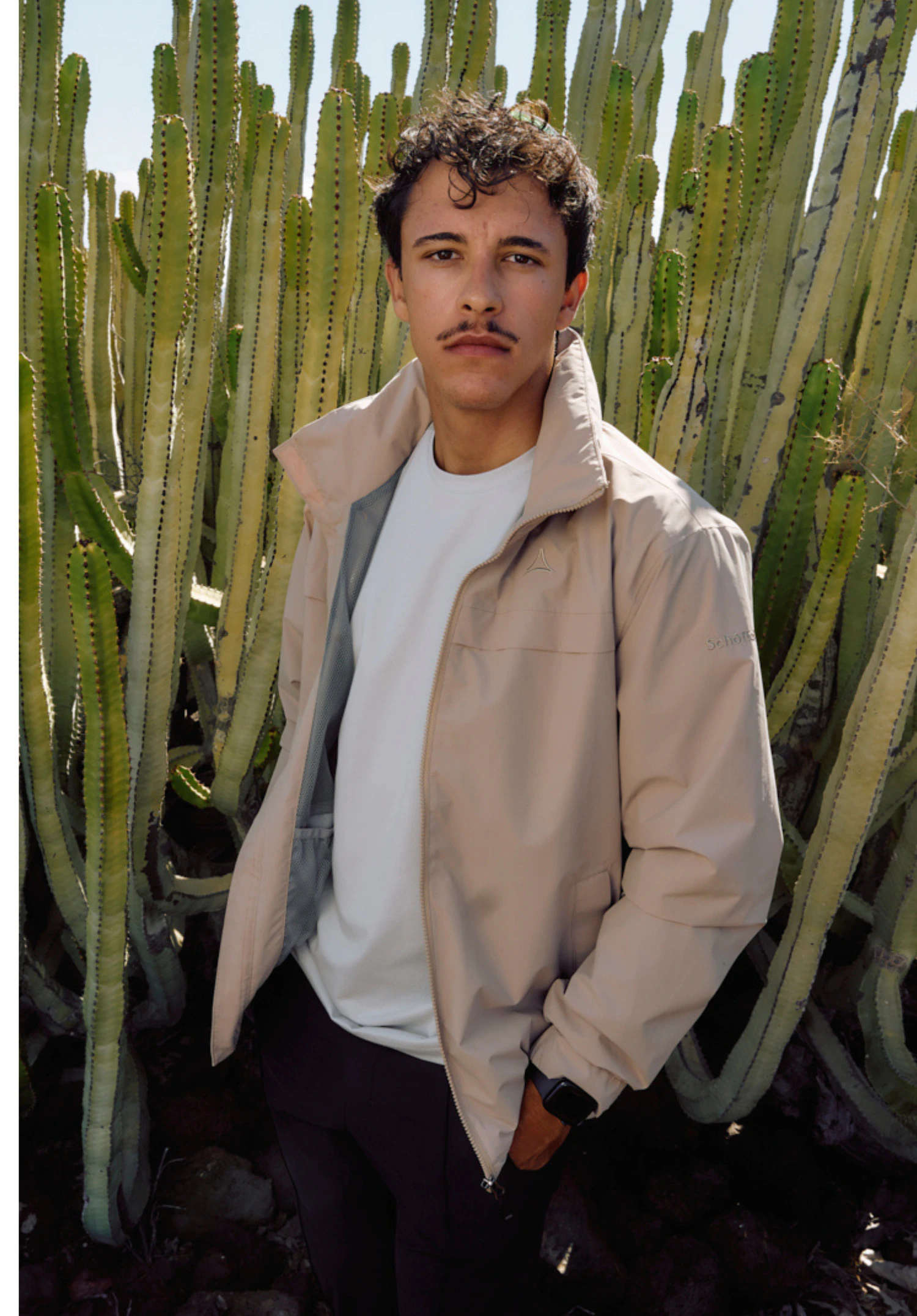 Jacket Style Bohorok MNS gedragen door een model dat lichtjes zijwaarts staat. De beige jas is gesloten en toont het Schöffel-logo op de linkerborst, gepresenteerd tegen een neutrale achtergrond.