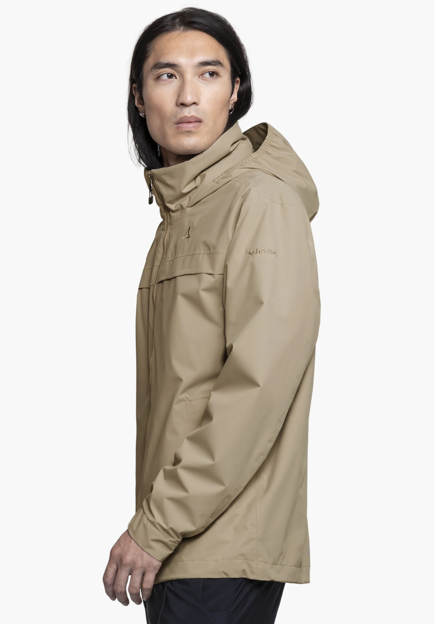 Jacket Style Bohorok MNS worn by a model standing sideways. The beige jacket features the Schöffel-Logo on the chest and sleeve, presented against a neutral background.