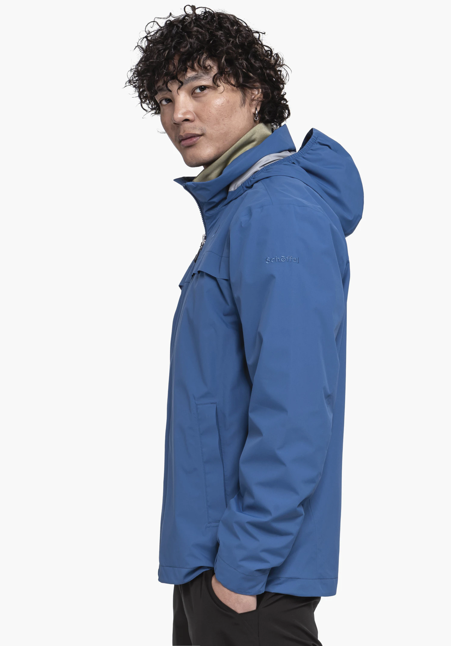 Jacket Style Bohorok MNS. A male model stands sideways in the blue jacket looking over his shoulder, with the Schöffel logo clearly visible on the sleeve, against a neutral background.