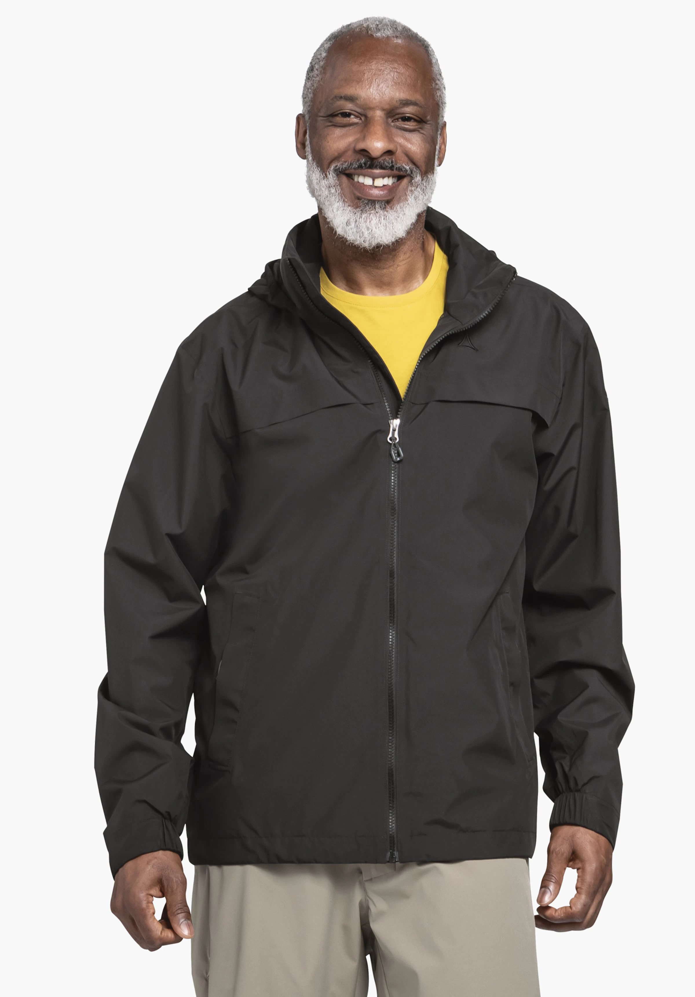 Jacket Style Bohorok MNS in Schwarz, getragen von einem Model, das frontal zur Kamera steht. Die Jacke hat einen teilweise geöffneten Reißverschluss, zeigt das Schöffel-Logo auf der linken Brust und wird vor einem neutralen Hintergrund präsentiert.