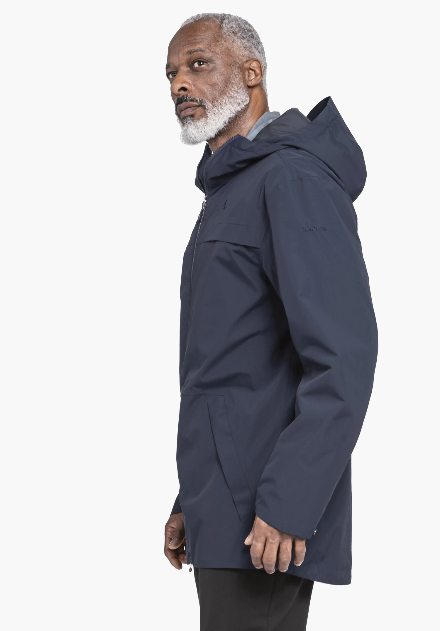 Parka Style Bohorok MNS porté par un mannequin qui se tient de profil, de couleur bleue. Le logo Schöffel est visible sur la manche gauche. L'image est présentée sur un fond neutre.
