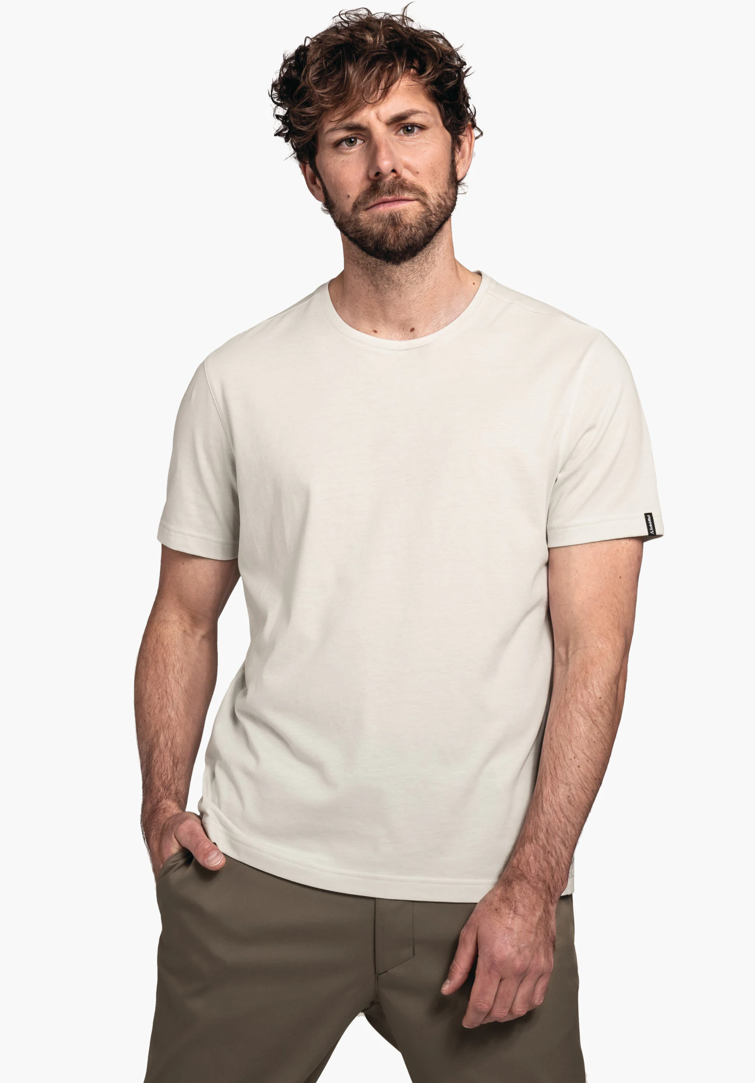 T Shirt Style Collada MNS gebroken wit T-shirt, gedragen door een man die frontaal staat met één hand in de zak van zijn donkerbruine broek; neutrale witte achtergrond.