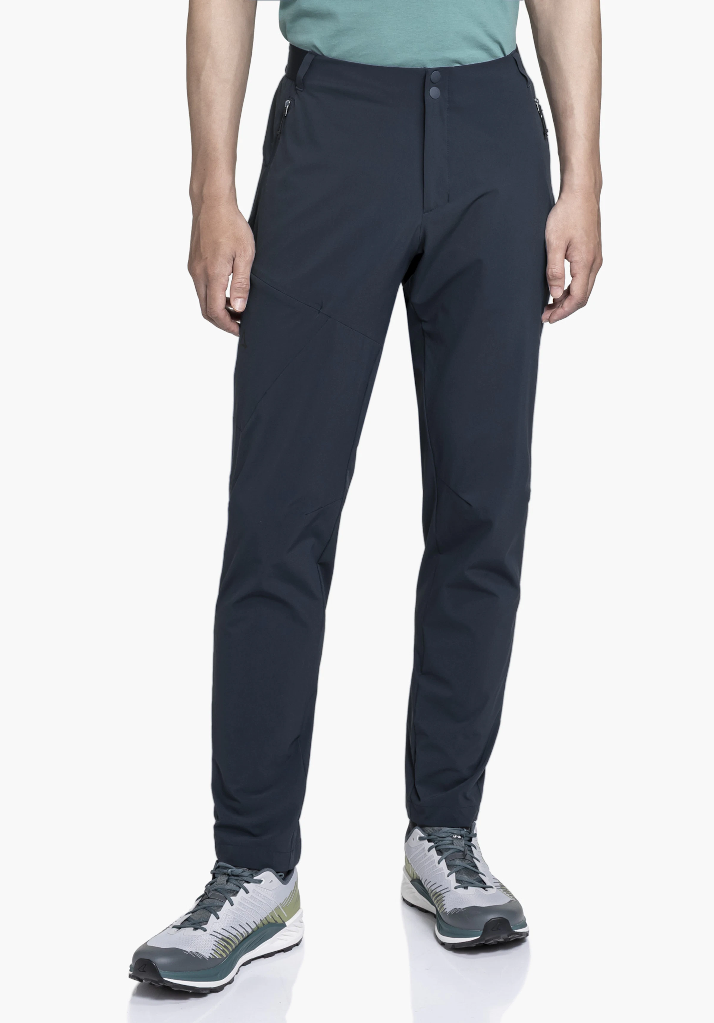 Pants Style Blaustein MNS in Blau. Das Model steht frontal vor einem neutralen Hintergrund und präsentiert die Hose in voller Länge, kombiniert mit sportlichen Wanderschuhen.