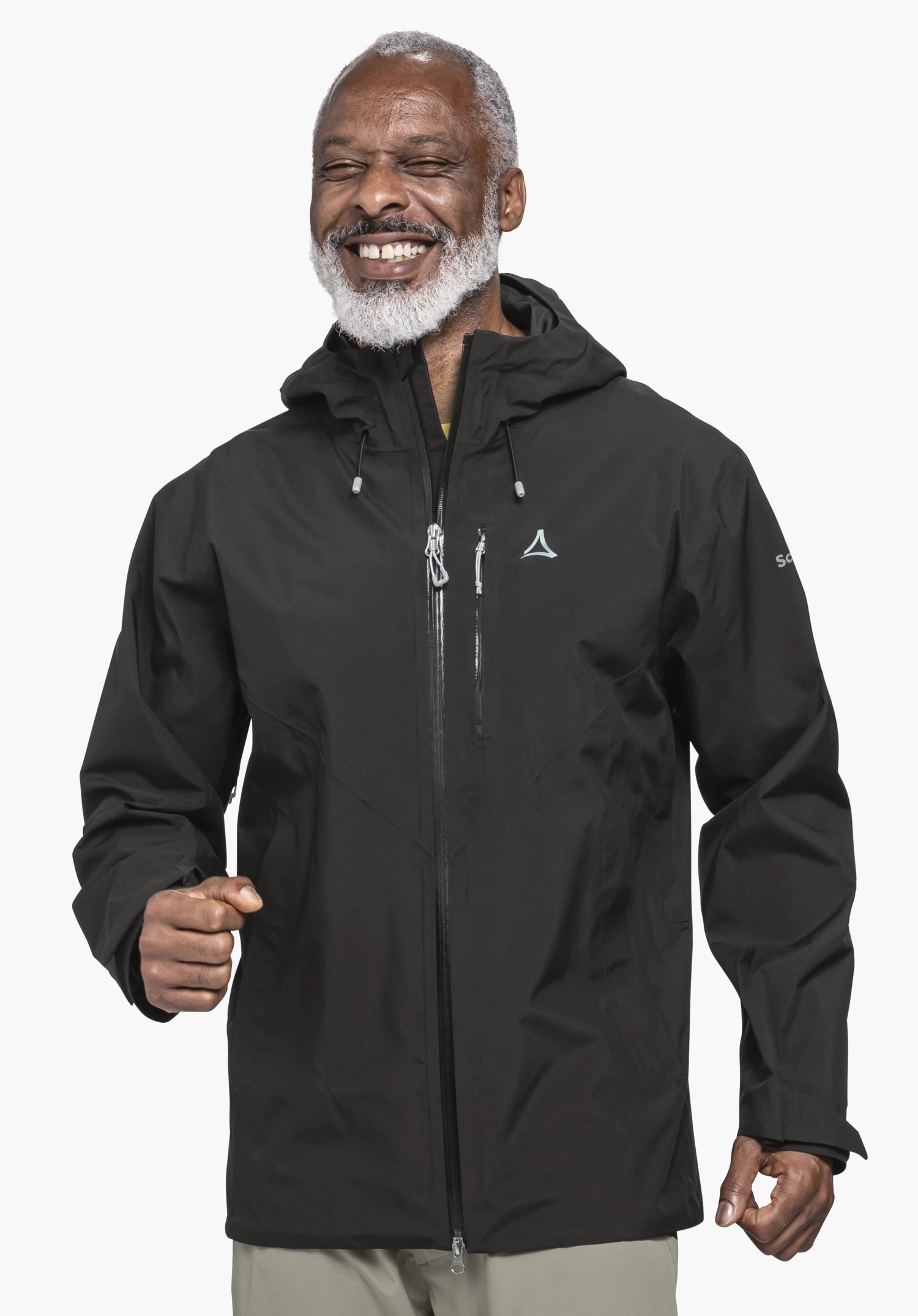 Jacket Style Mauku MNS gedragen door een lachend model in het zwart. Het model staat frontaal met licht gebogen armen en een zichtbaar Schöffel-logo op de borst tegen een neutrale achtergrond.