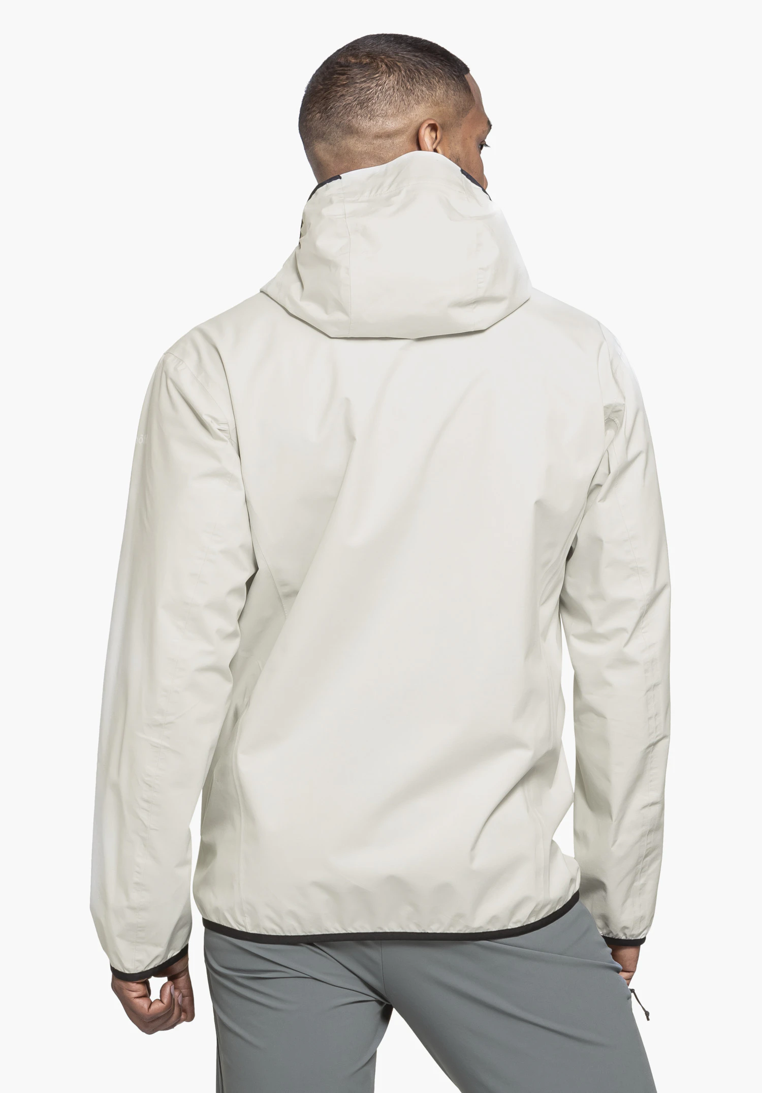 Jacket Style Migandi MNS in der Farbe natur wird in der Rückenansicht von einem Model vor einem neutralen Hintergrund getragen; das dezente Schöffel-Logo ist am Ärmel erkennbar.
