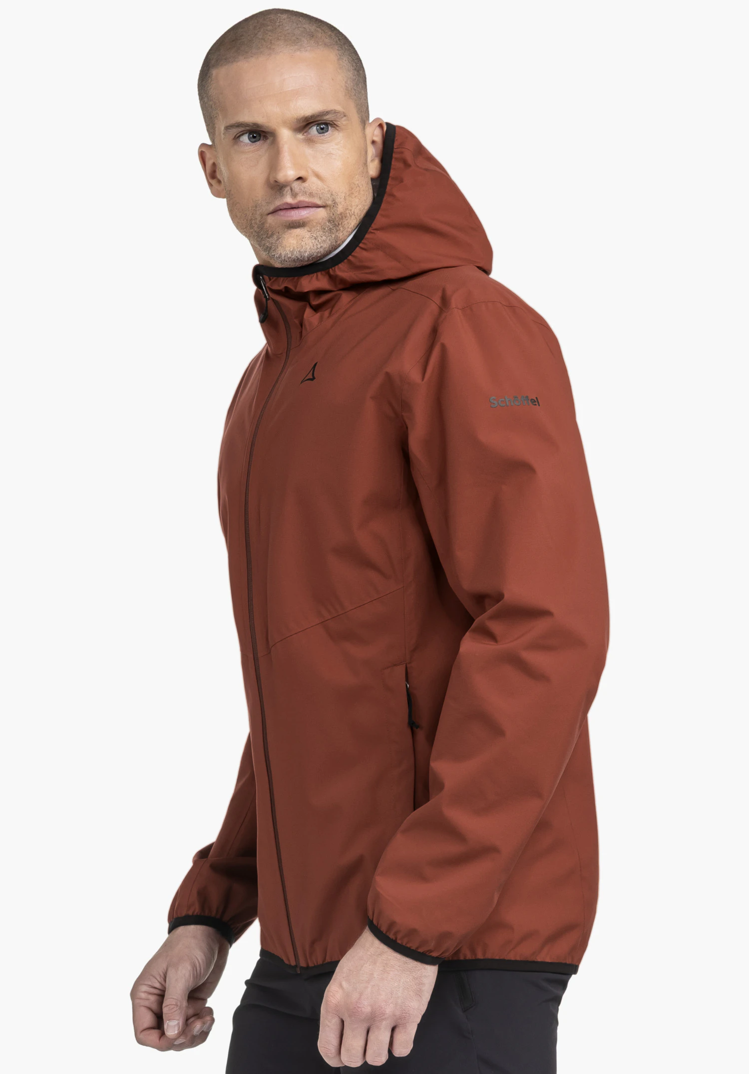 Jacket Style Migandi MNS. A male model is wearing the zipped jacket in the colour red, standing sideways against a neutral background. The Schöffel logo is visible on the chest and on the left sleeve.