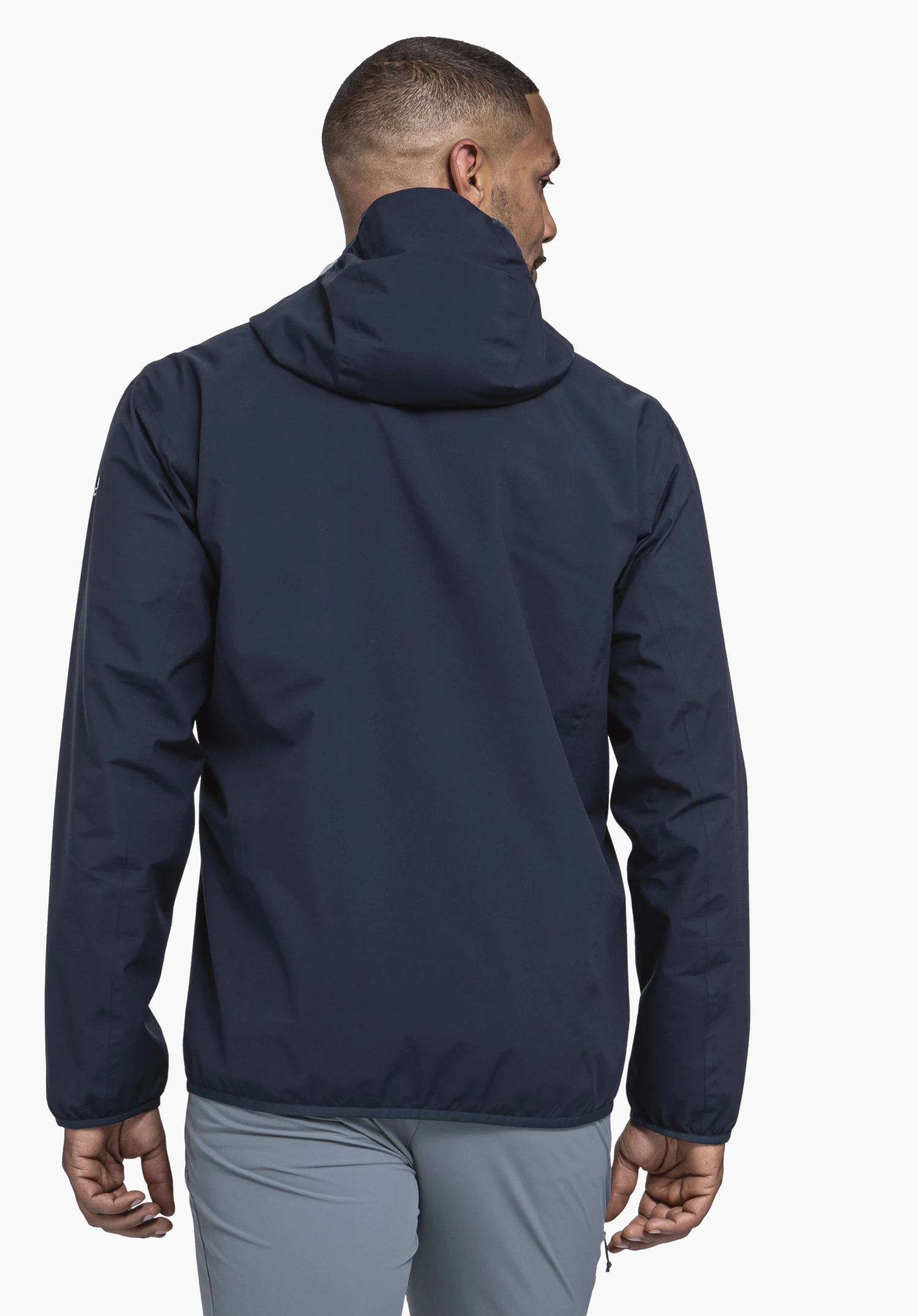 Jacket Style Migandi MNS dark blue hooded jacket worn from the back; person stands slightly turned with hands relaxed at the sides; white background.