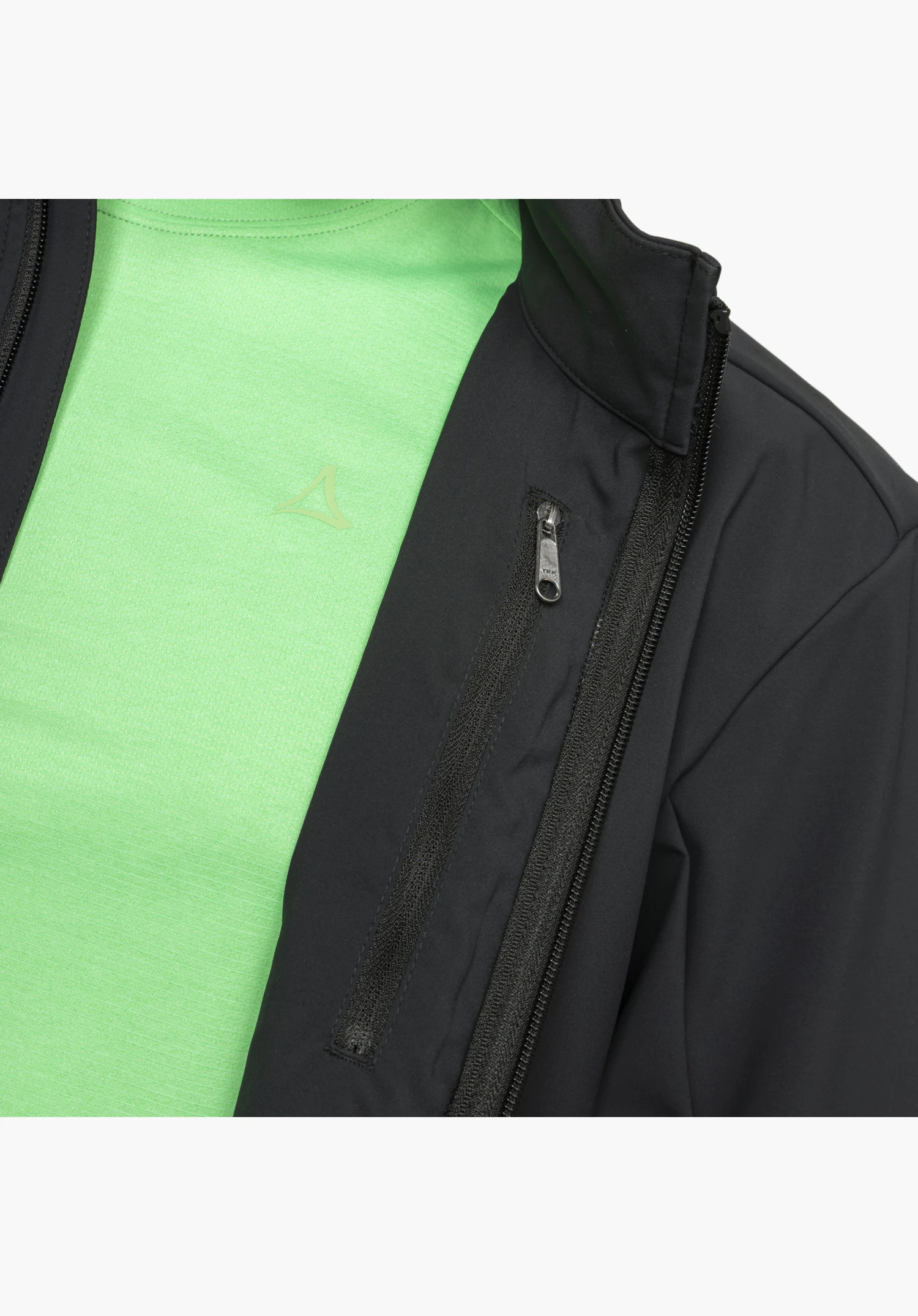 Softshell Jk Style Mirusha MNS montre en détail le tissu noir, la fermeture éclair frontale ouverte et la poche poitrine zippée, combinés avec un t-shirt vert en dessous arborant le logo Schöffel, gros plan sur fond blanc/neutre.