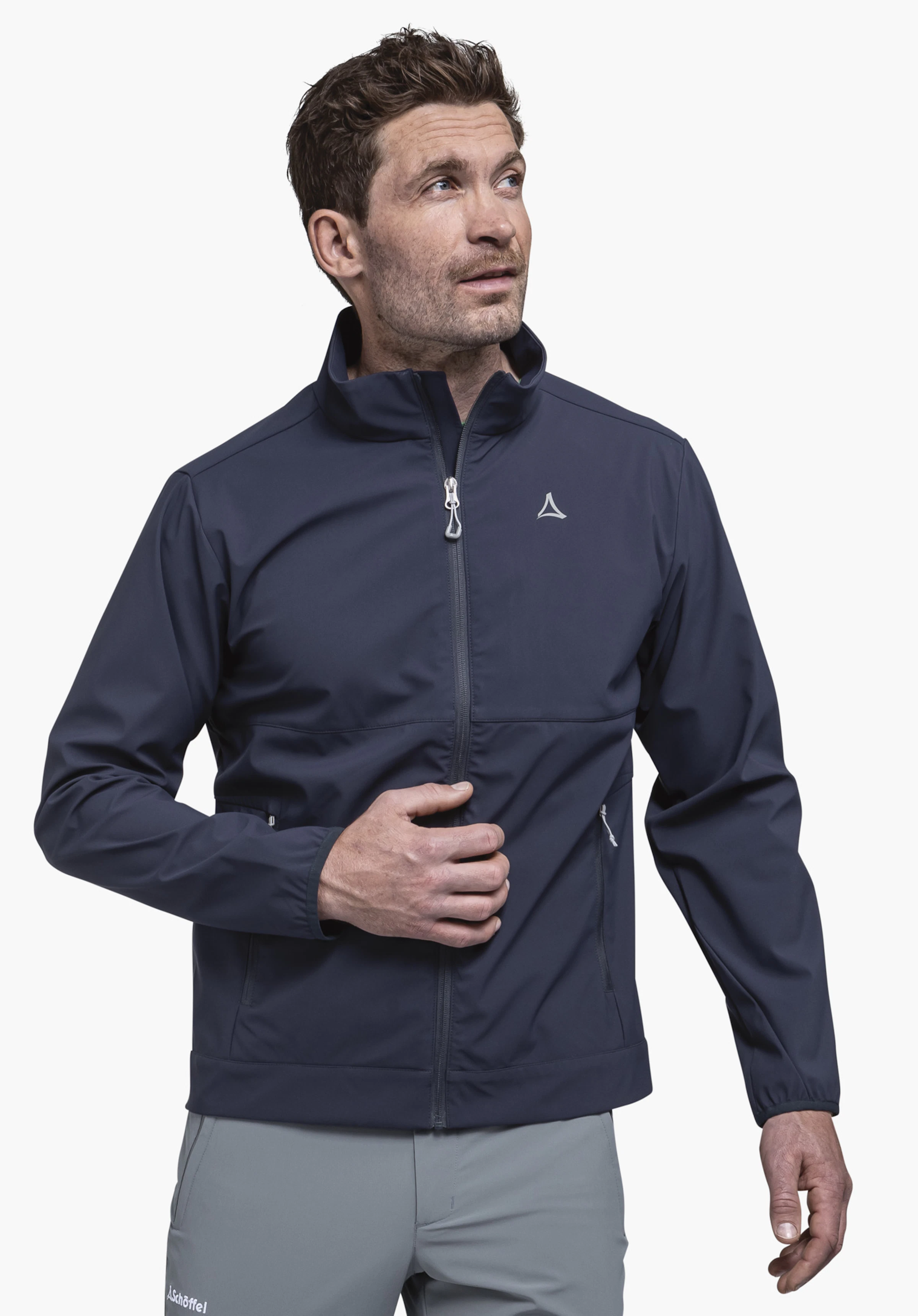 Softshell Jk Style Mirusha MNS worn by a male model standing in a frontal pose. The blue jacket featuring the visible Schöffel logo on the left chest is presented against a neutral background.
