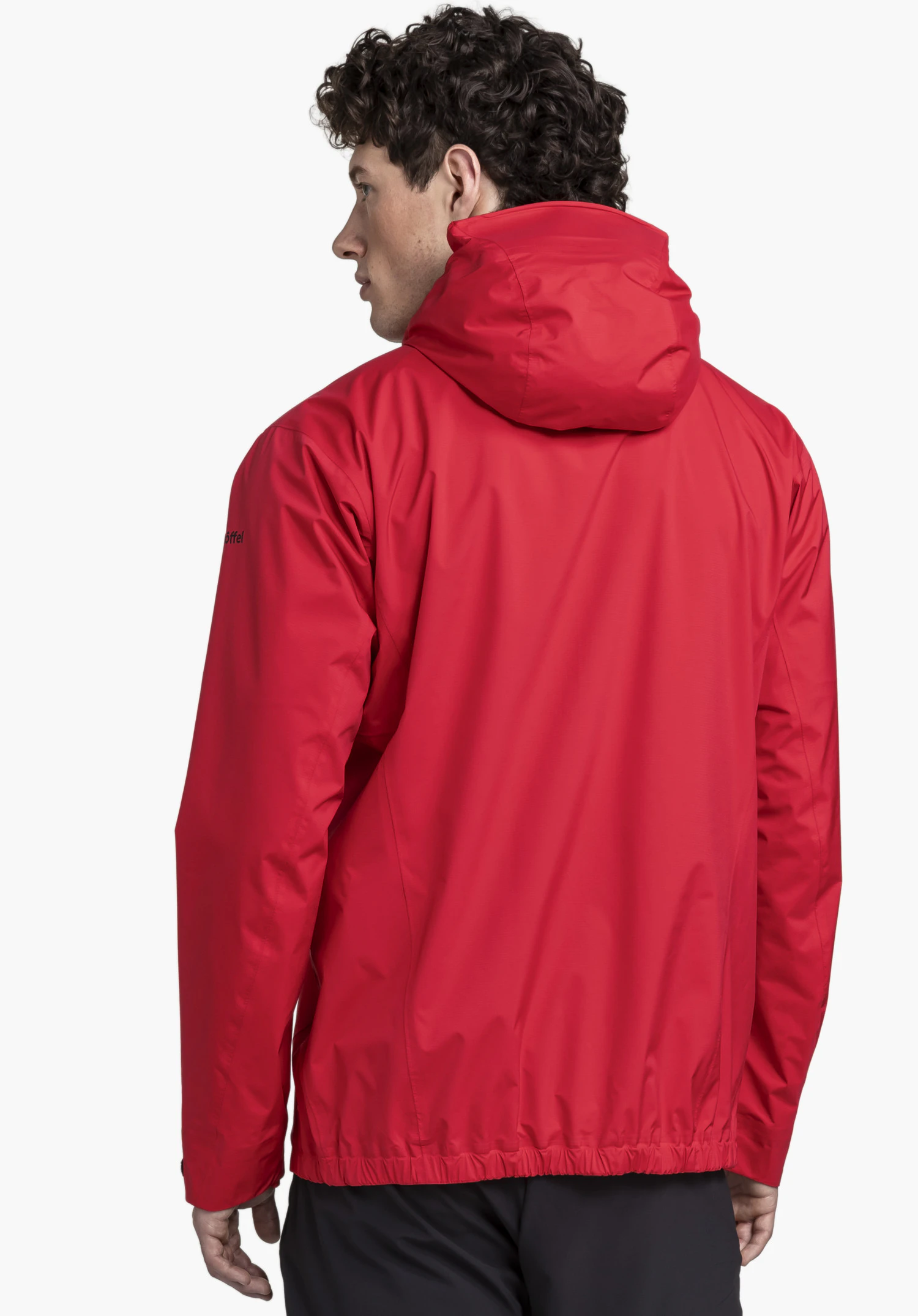 2.5L 3D Jacket Vistdal M en rouge. Le mannequin se tient de dos pour présenter la coupe de la veste, avec le logo Schöffel visible sur la manche gauche, photographié sur un fond neutre.