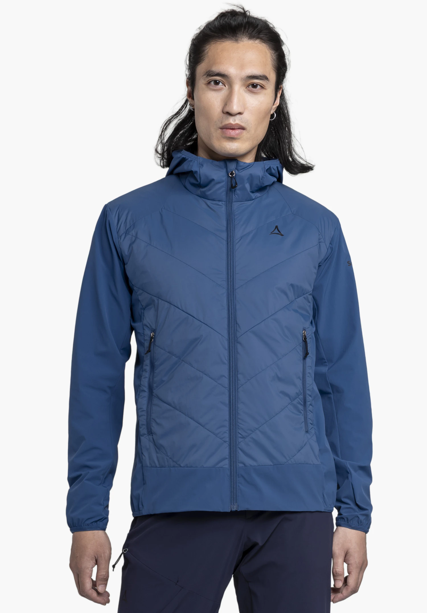 Hybrid Jk Style Blaueis MNS wordt gedragen door een model dat frontaal staat. De blauwe jas toont het zichtbare Schöffel-logo op de linkerborst en wordt gepresenteerd tegen een neutrale achtergrond.