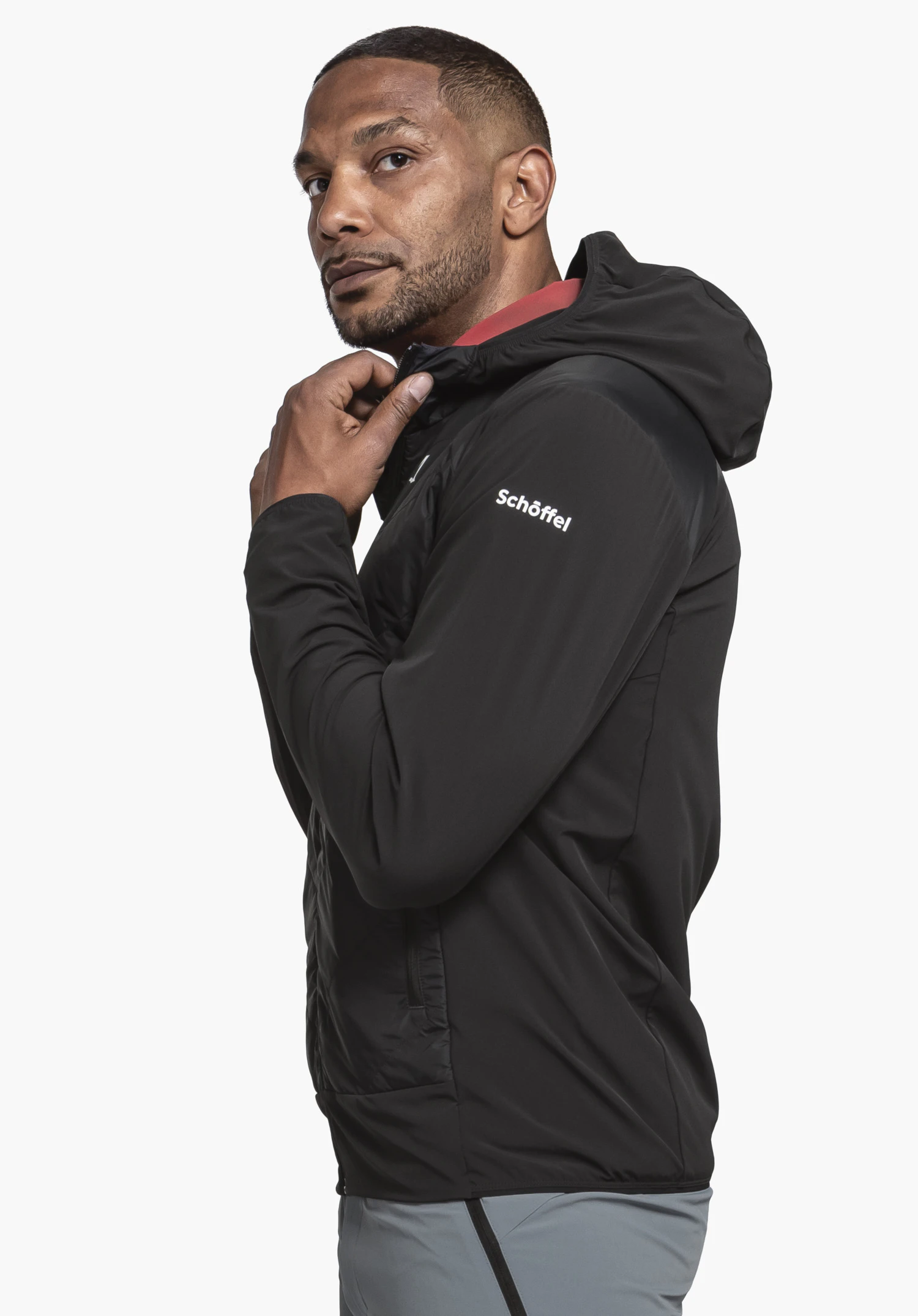 Hybrid Jk Style Blaueis MNS in black, worn by a model standing in profile. The white Schöffel logo is clearly visible on the upper arm. The image features a neutral background.