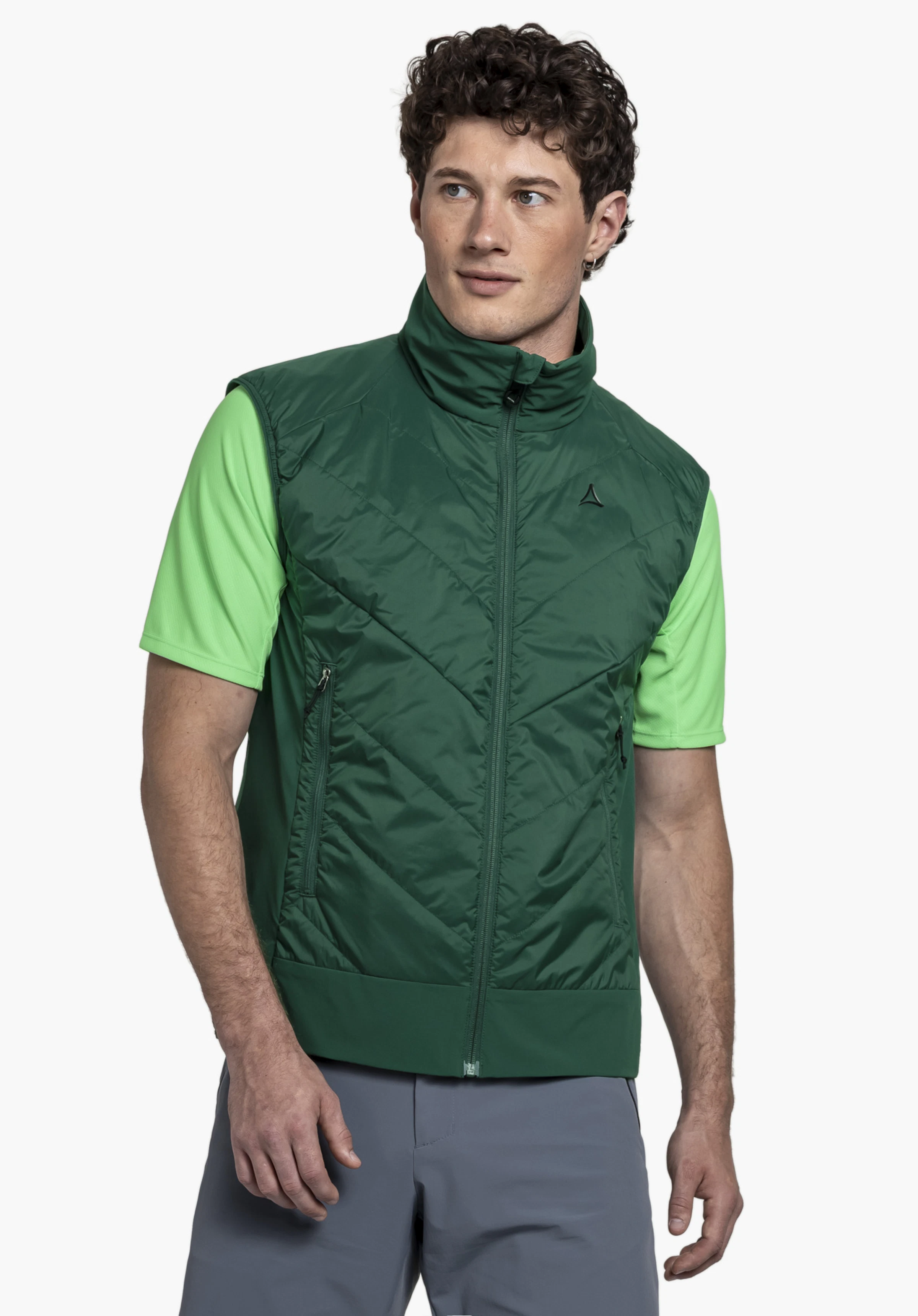 Hybrid Vt Style Blaueis MNS. A model stands slightly to the side wearing the vest in green with a visible Schöffel logo on the left chest in front of a neutral background.