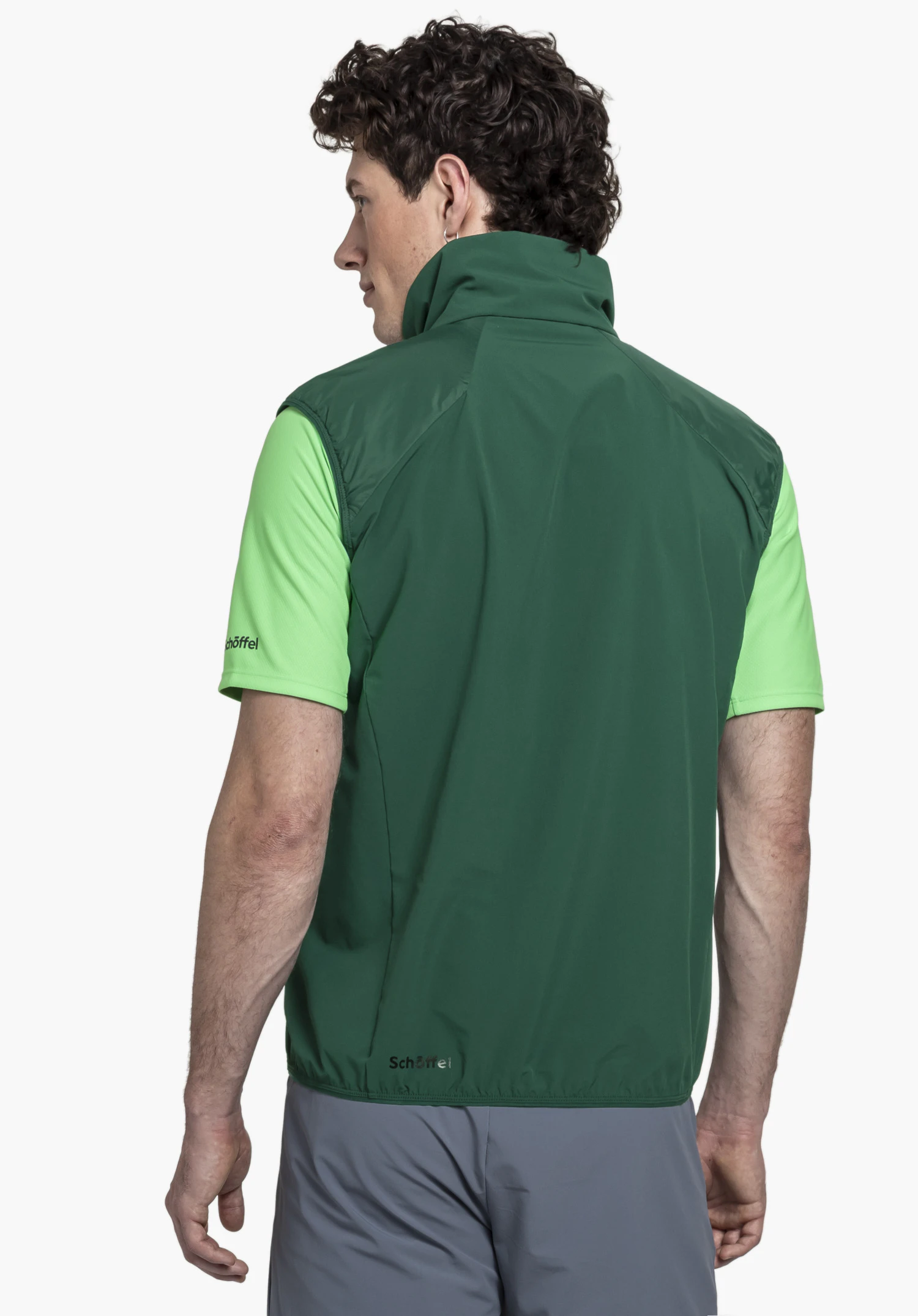Hybrid Vt Style Blaueis MNS in green, worn by a model in a back view with a visible Schöffel logo on the lower hem, presented against a neutral background.