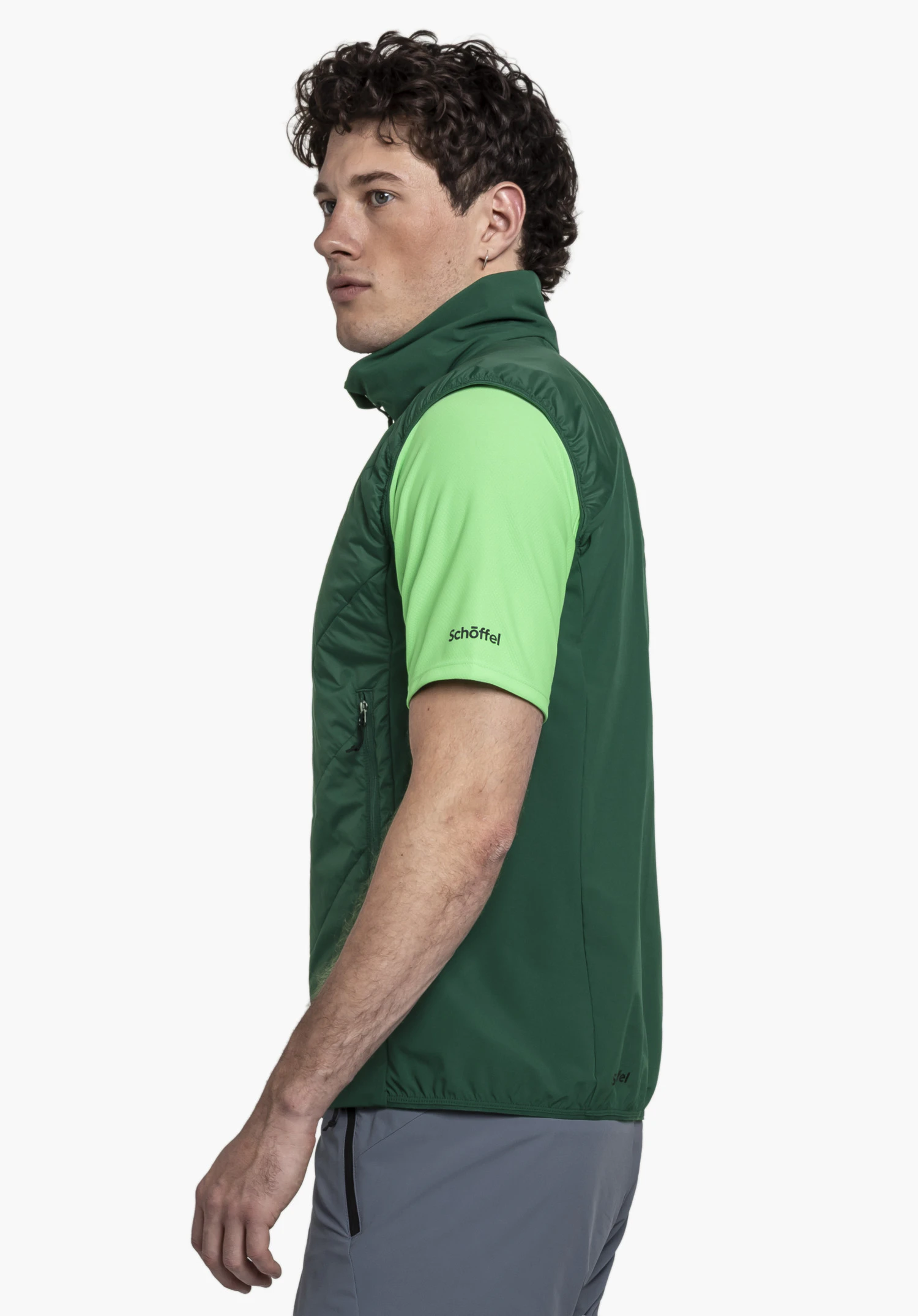 Hybrid Vt Style Blaueis MNS. A model stands sideways presenting the green gilet with a visible Schöffel logo against a neutral background.