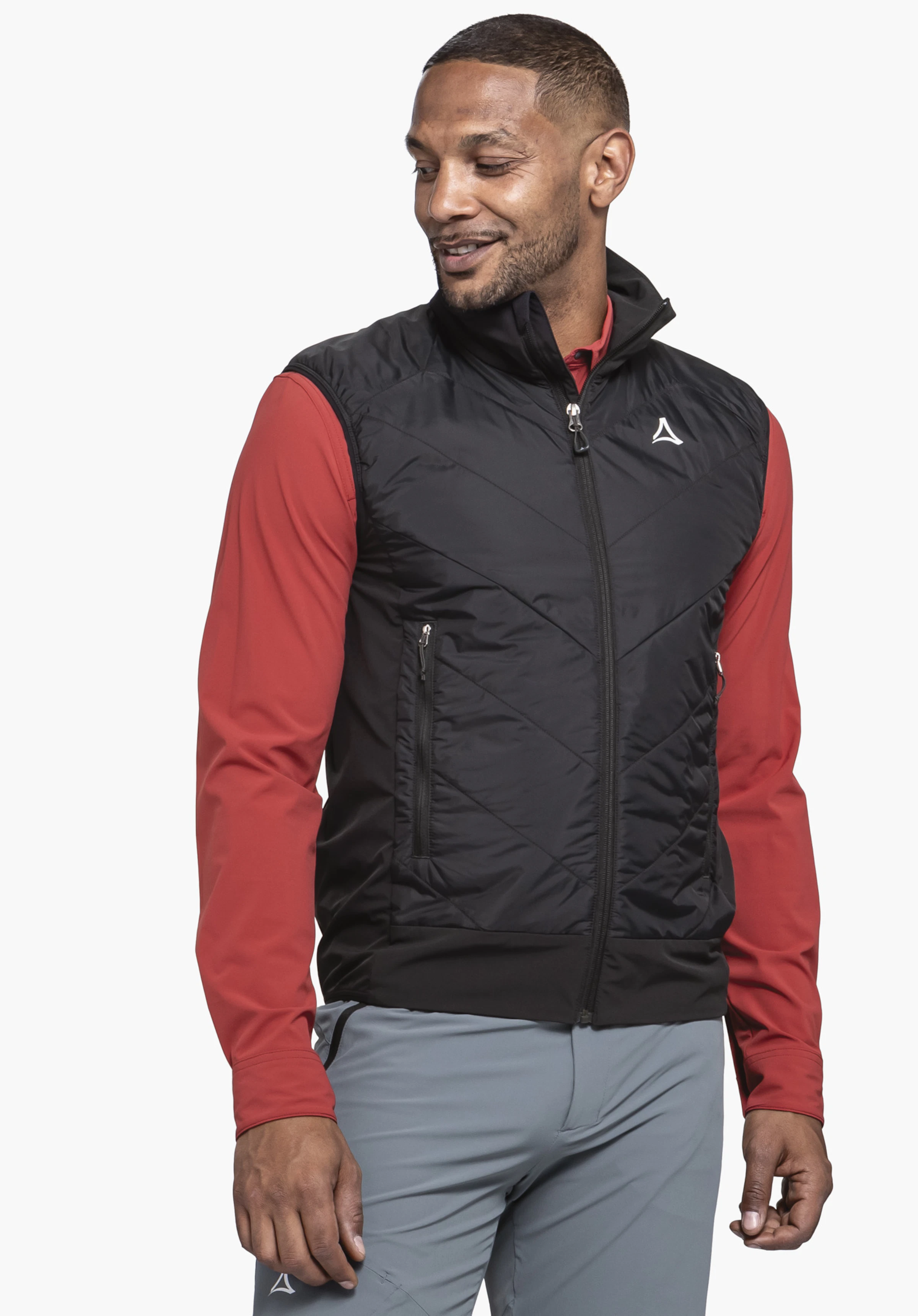Hybrid Vt Style Blaueis MNS worn by a model standing slightly to the side. The black gilet features a distinct Schöffel-Logo on the left chest, presented against a neutral background.