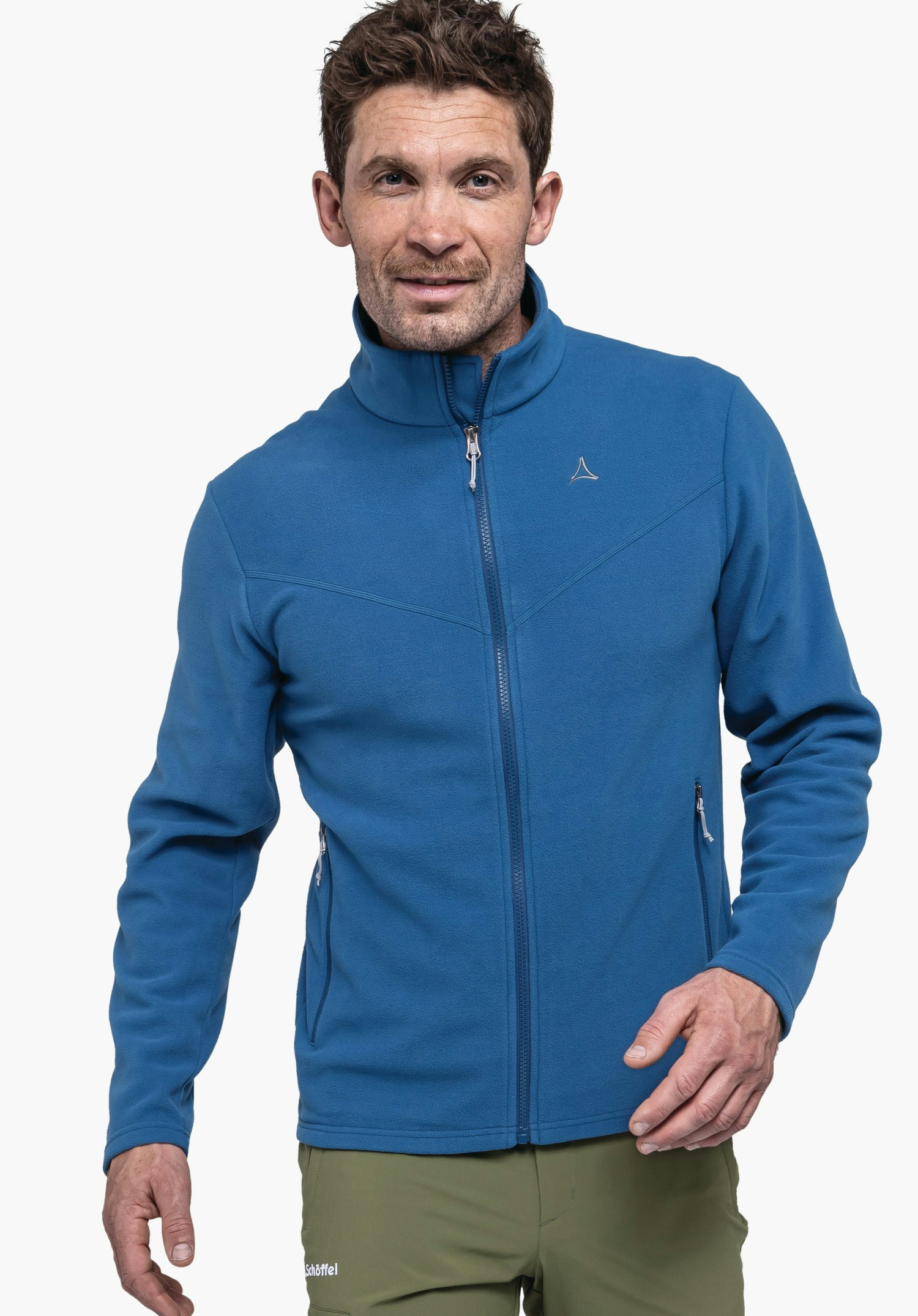Fleece Jk Style Qutang MNS an einem Model, das frontal steht und in die Kamera blickt. Die blaue Fleecejacke ist geschlossen und zeigt das Schöffel-Logo auf der linken Brust. Das Kleidungsstück wird vor einem neutralen Hintergrund präsentiert.