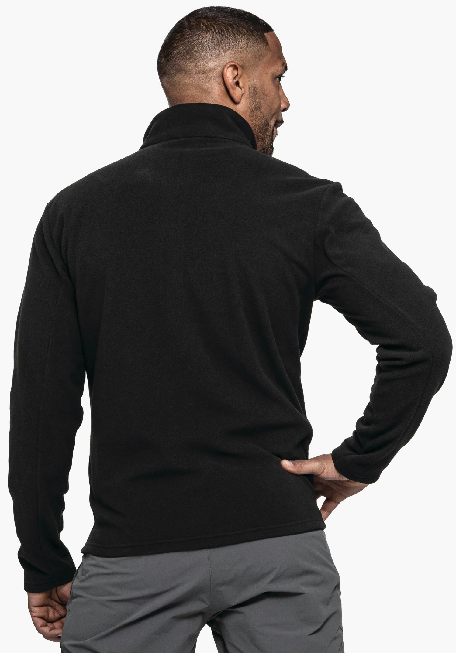 Fleece Jk Style Qutang MNS schwarzer Pullover, getragen von einem Mann in Rückenansicht; rechter Arm in Hüfte gestützt, hellgraue Hose, hellweißer Hintergrund.
