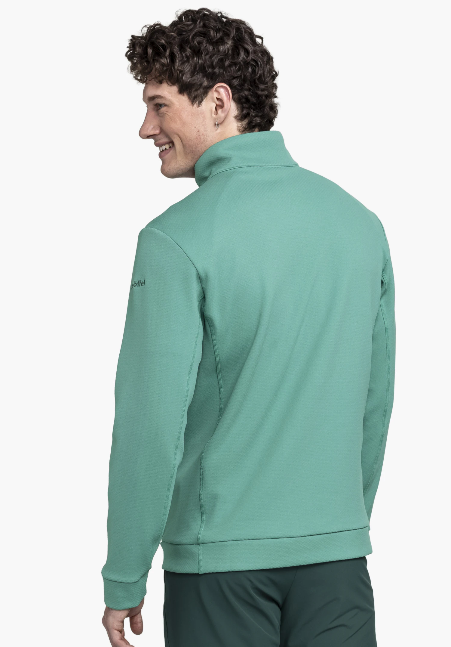 Fleece Jk Style Uriezzo MNS en vert, présenté de dos sur un mannequin regardant par-dessus son épaule, avec le logo Schöffel visible sur le haut du bras sur fond neutre.