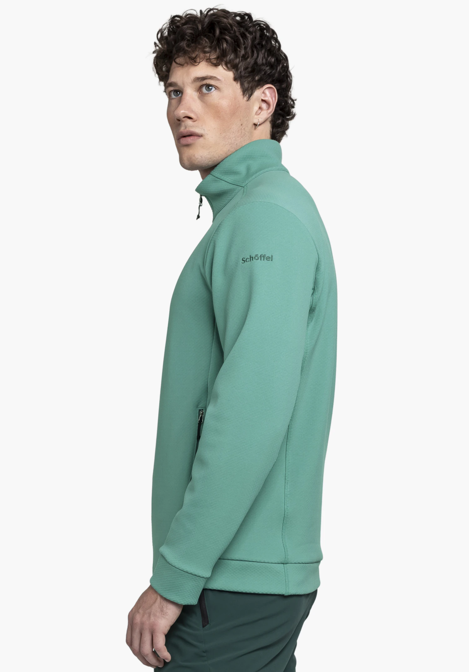 Fleece Jk Style Uriezzo MNS en vert : Un mannequin masculin présente la veste de profil sur un fond neutre, le logo Schöffel étant discrètement visible sur le haut du bras.